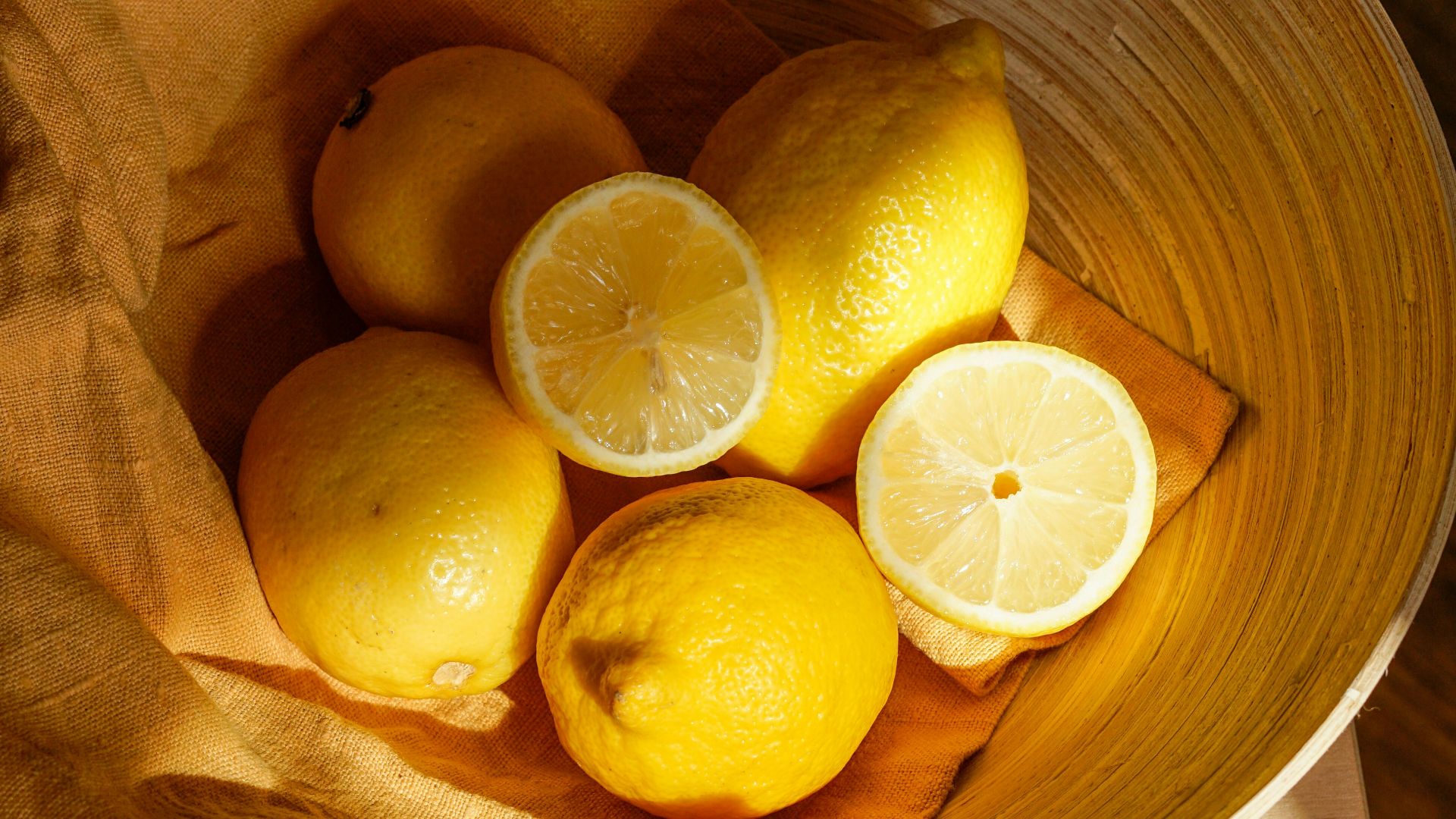 yellow lemon fruit in brown wooden bucket