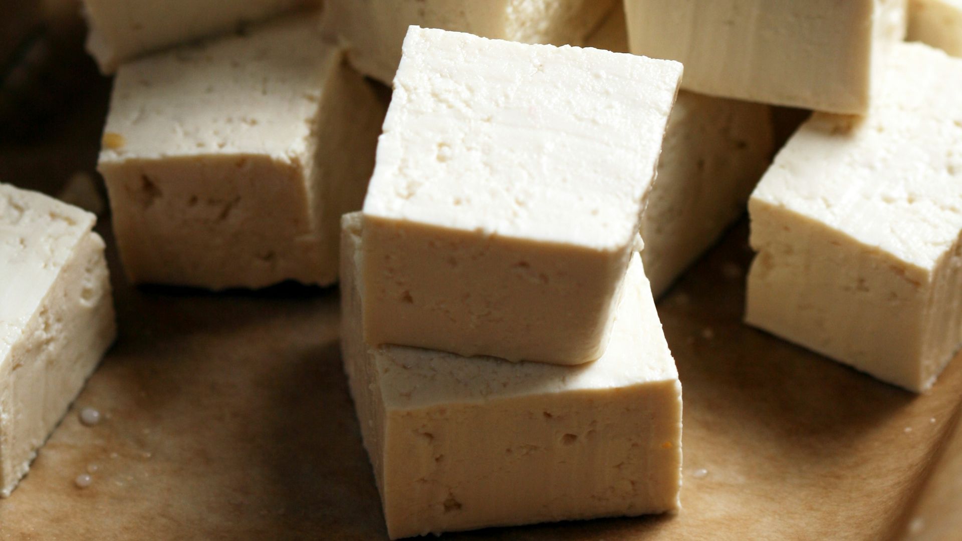 A pile of tofu cubes sitting on top of a cutting board