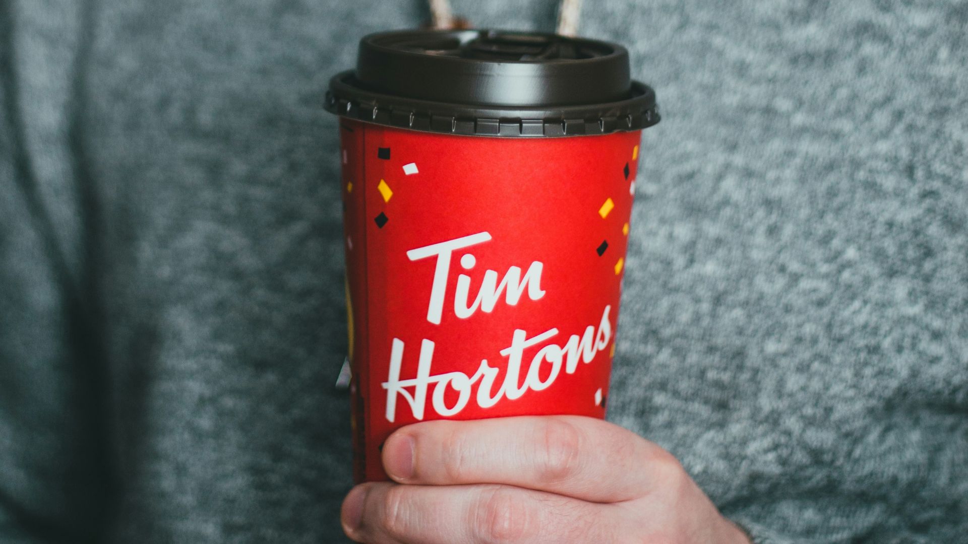 woman holding red and black disposable cup
