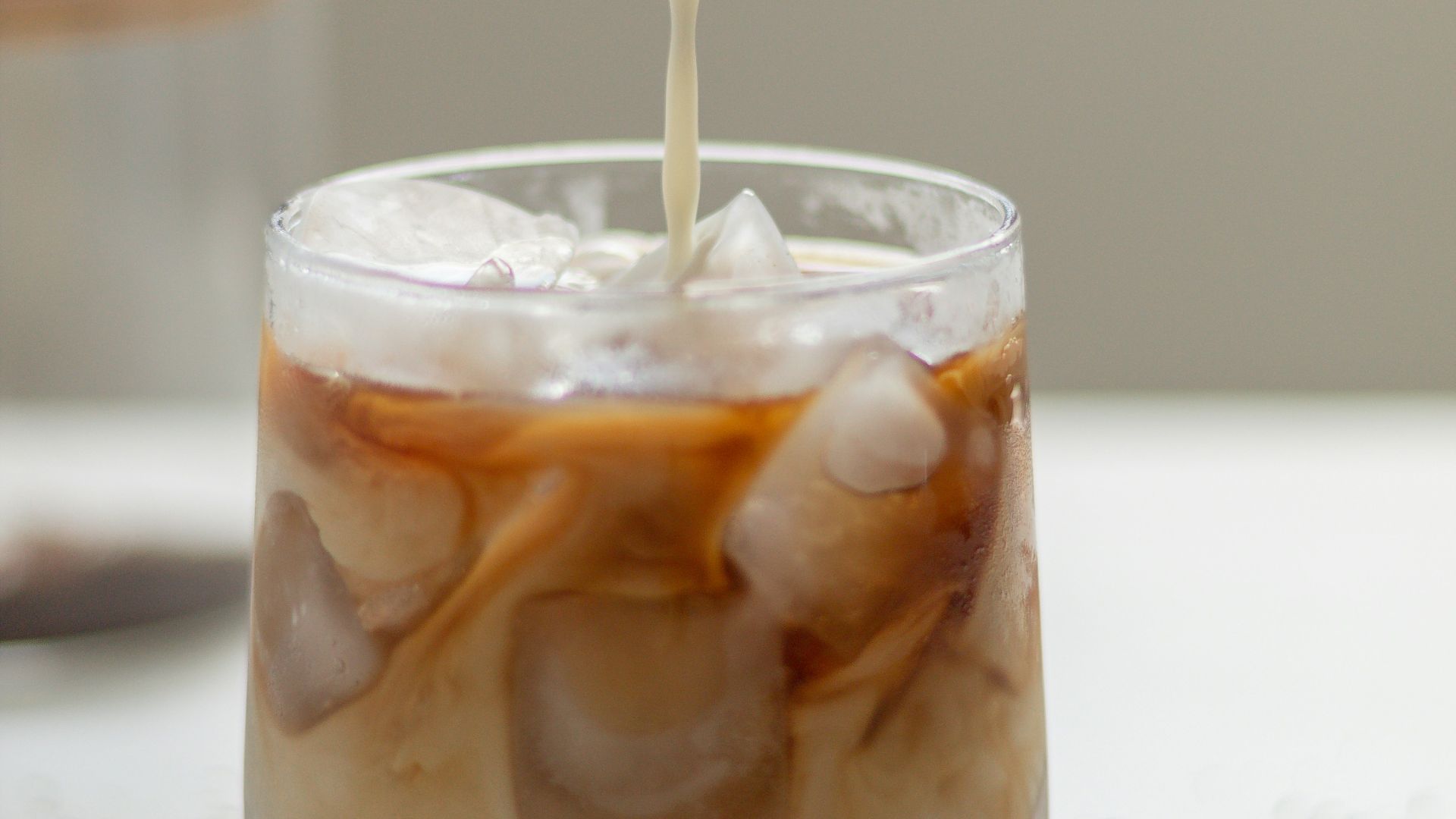 a person pouring a beverage into a glass