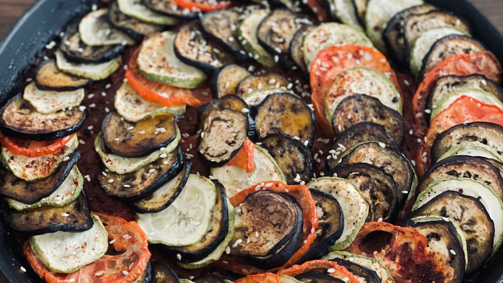 a pan filled with sliced up vegetables on top of a wooden table