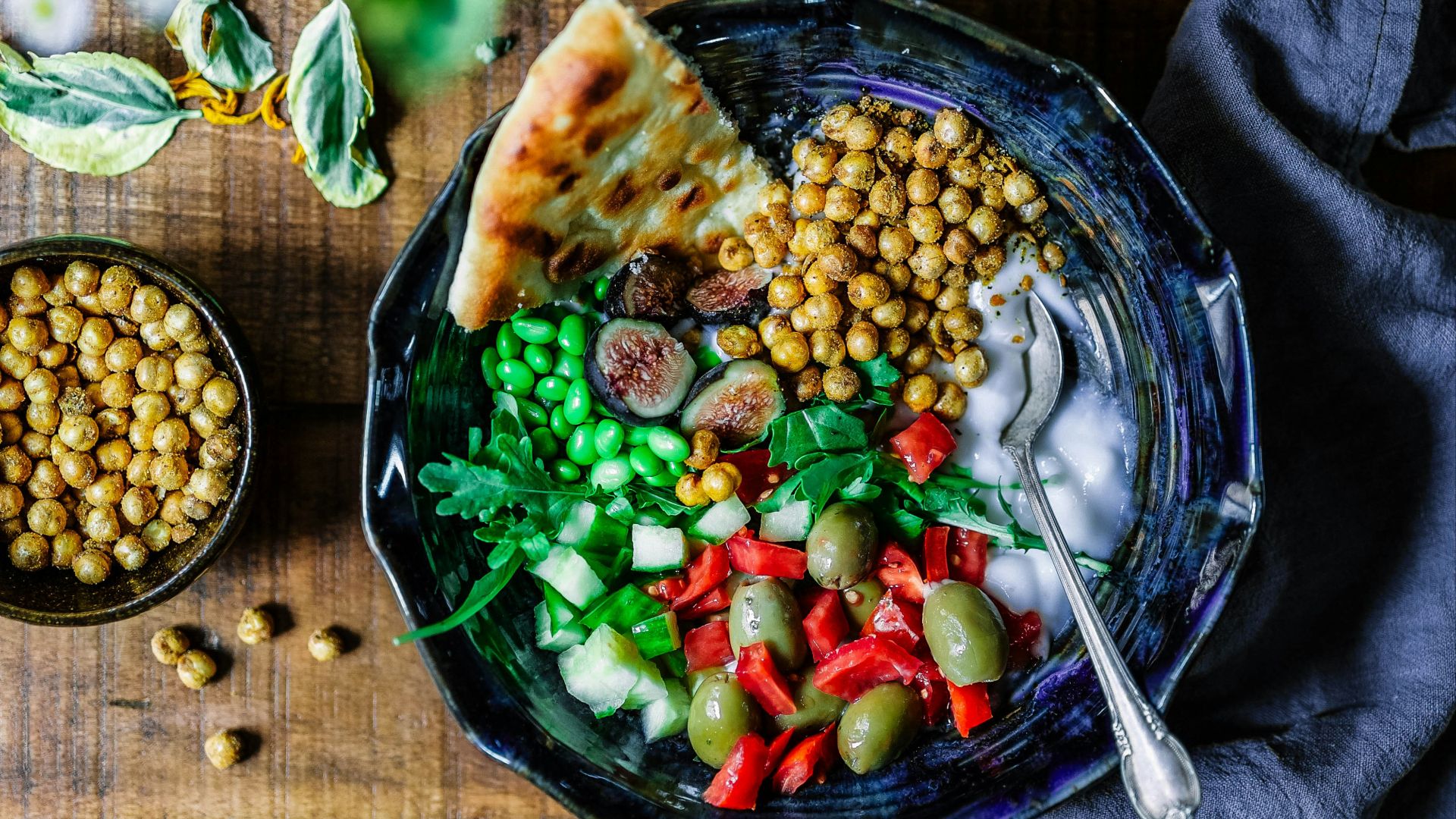 silver spoon on black ceramic bowl with vegetables