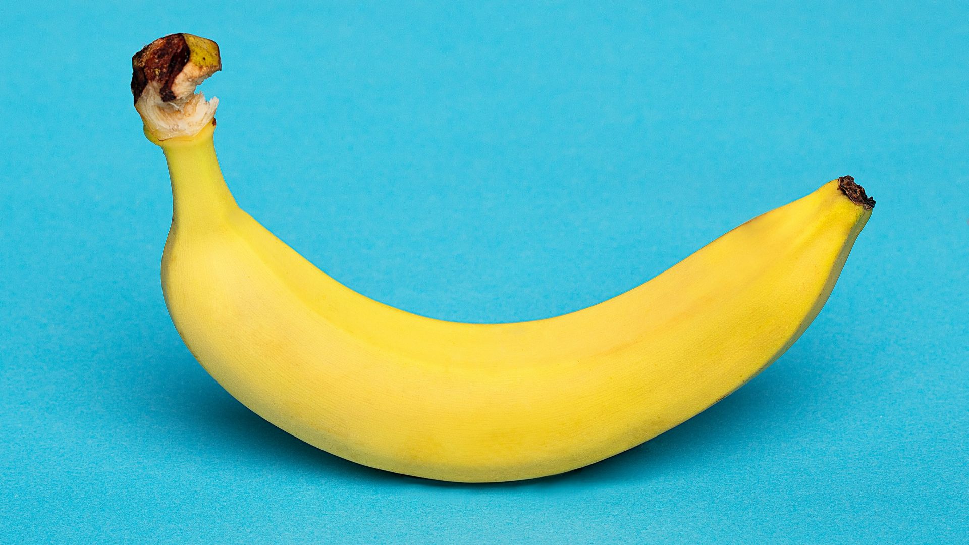 yellow banana fruit on blue surface
