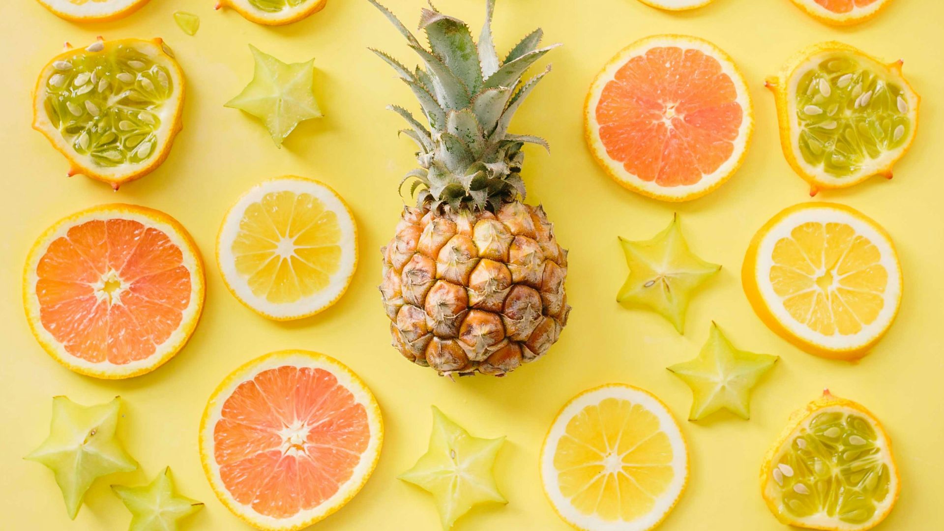pineapple surrounded by citrus fruits