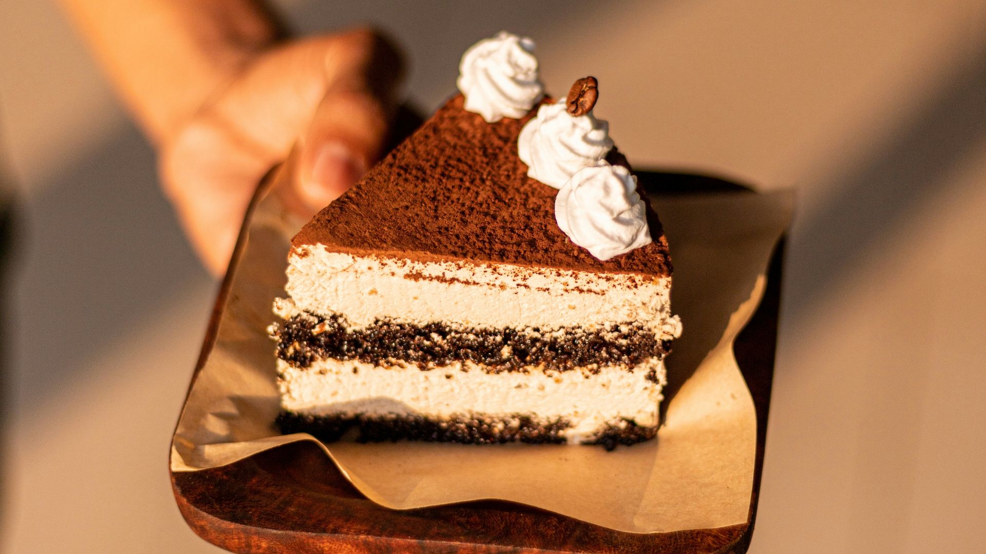 a person holding a piece of cake on a plate