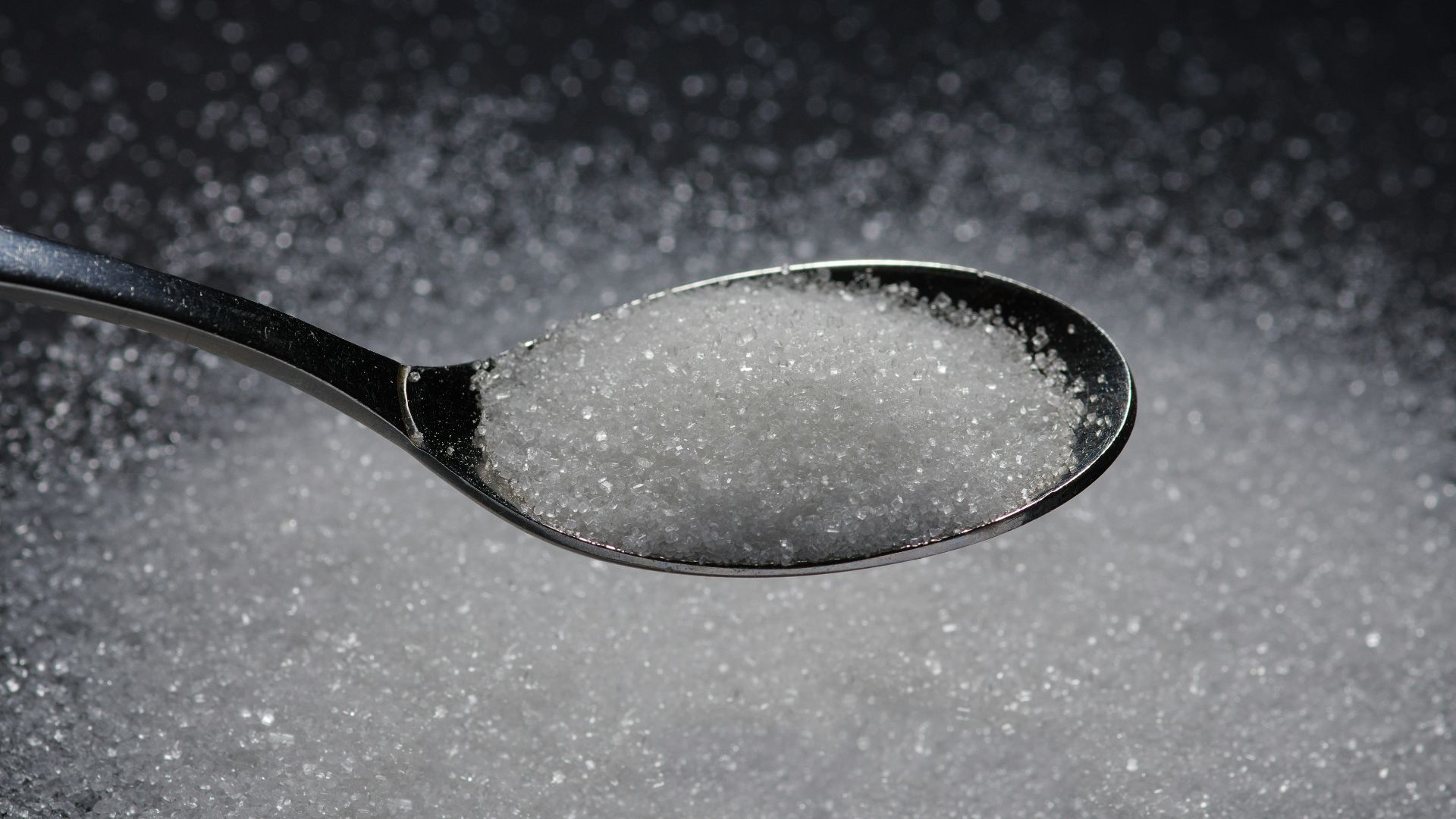 a spoon filled with sugar on top of a table