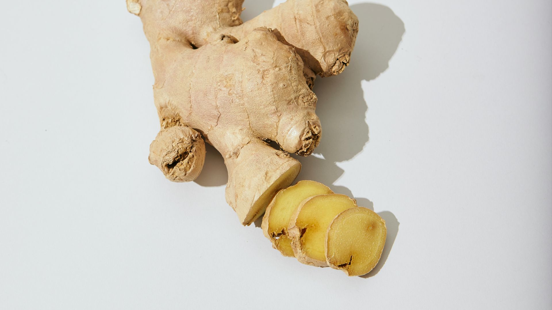 a ginger root and a piece of ginger on a white surface