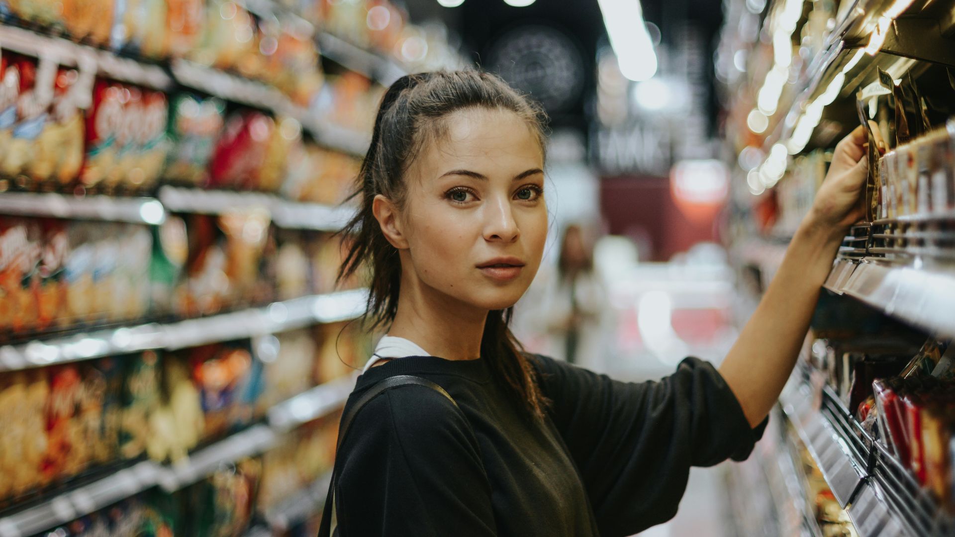 woman selecting packed food on gondola