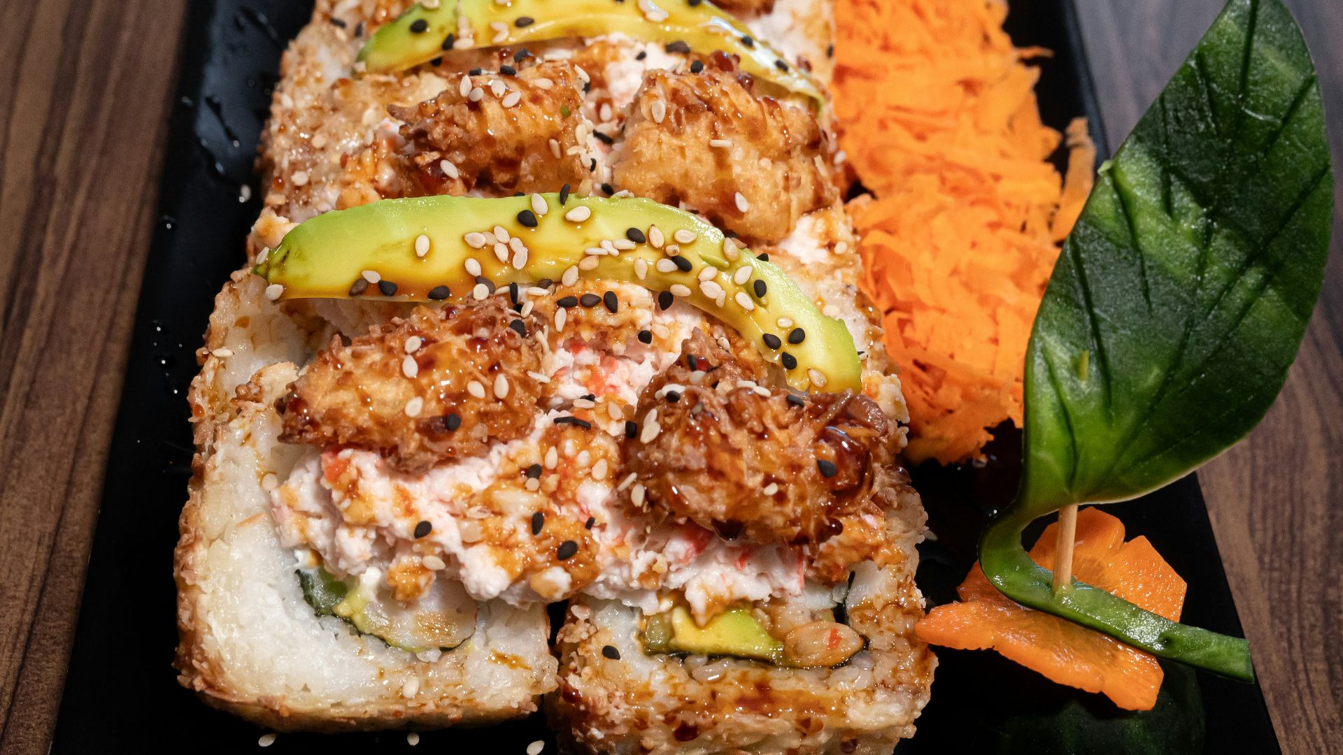 A black plate topped with meat and veggies