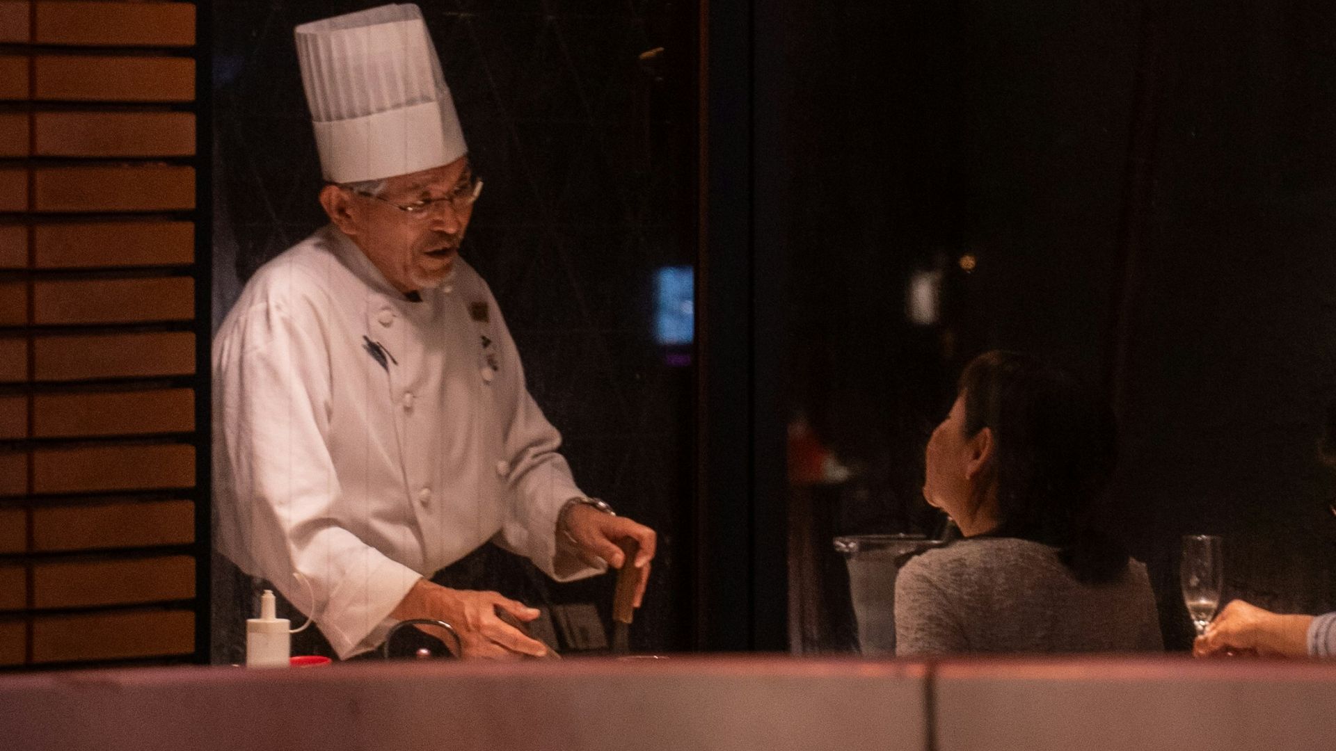 Chef preparing food behind a window.