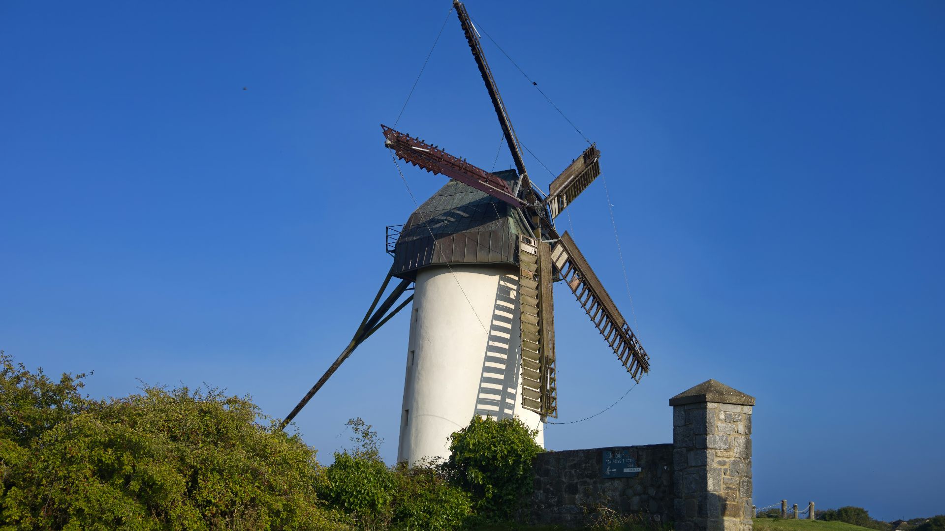 A windmill sitting on top of a lush green field