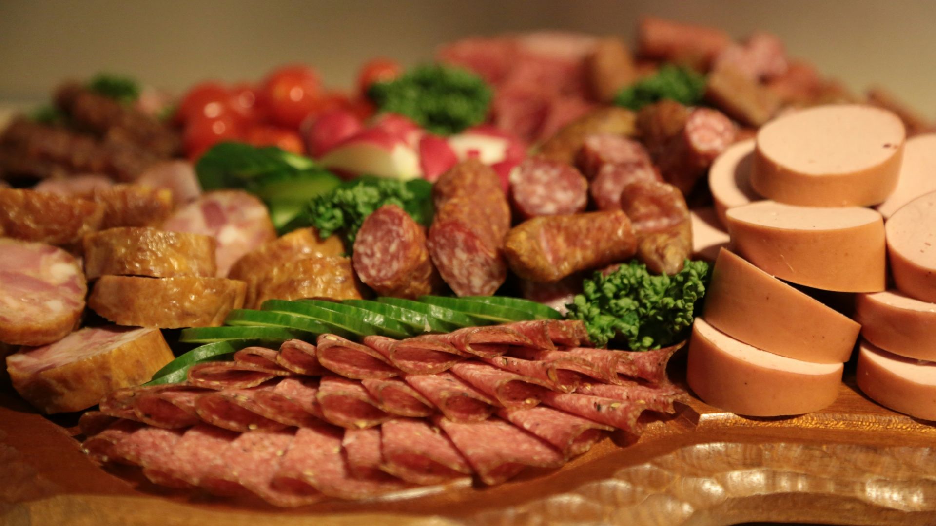sliced meat with green vegetable on brown wooden round plate