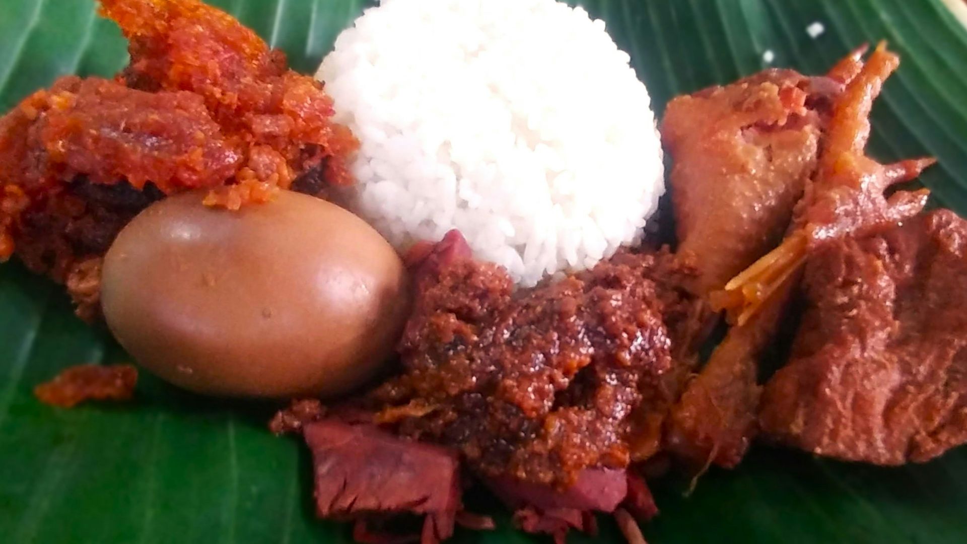 a close up of a plate of food on a banana leaf