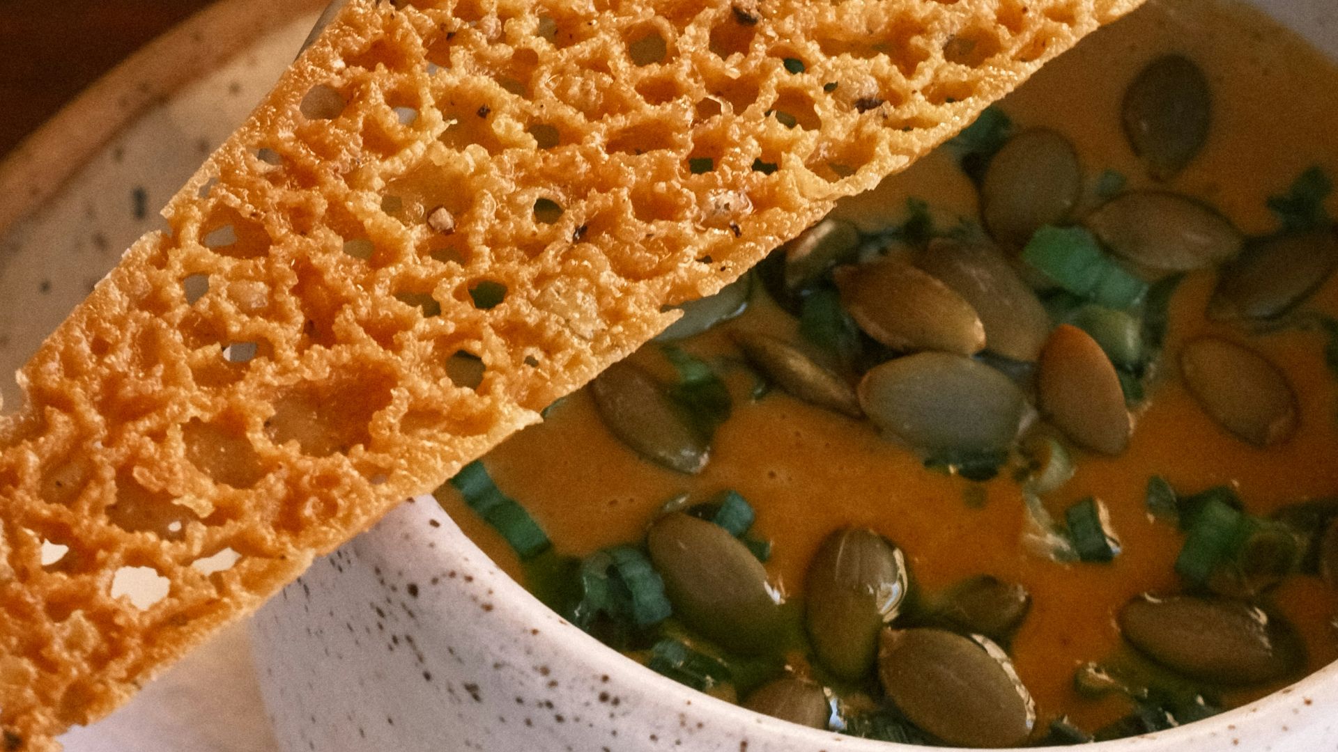 a bowl of soup with a piece of bread sticking out of it