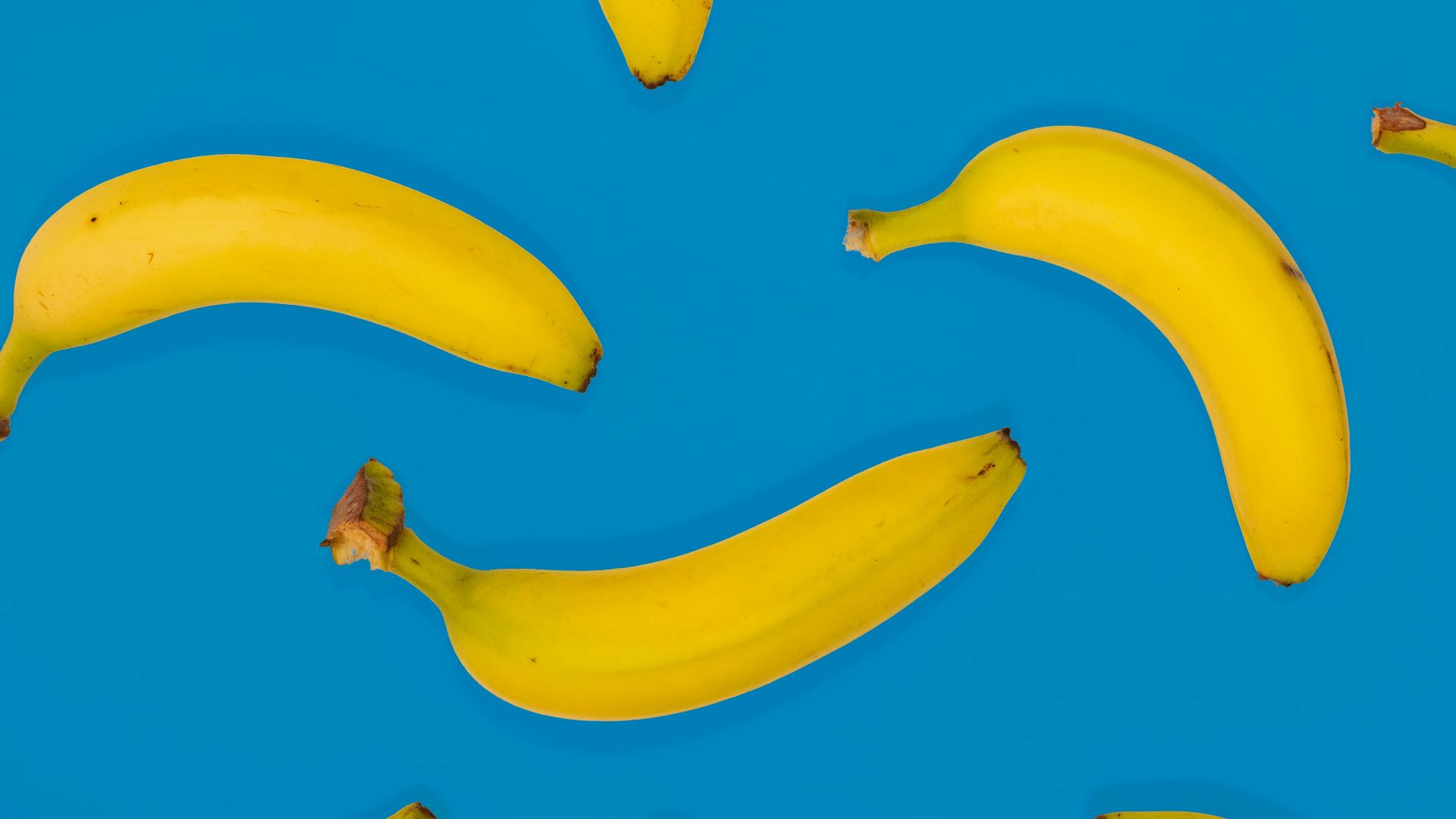 yellow banana fruits on blue surface