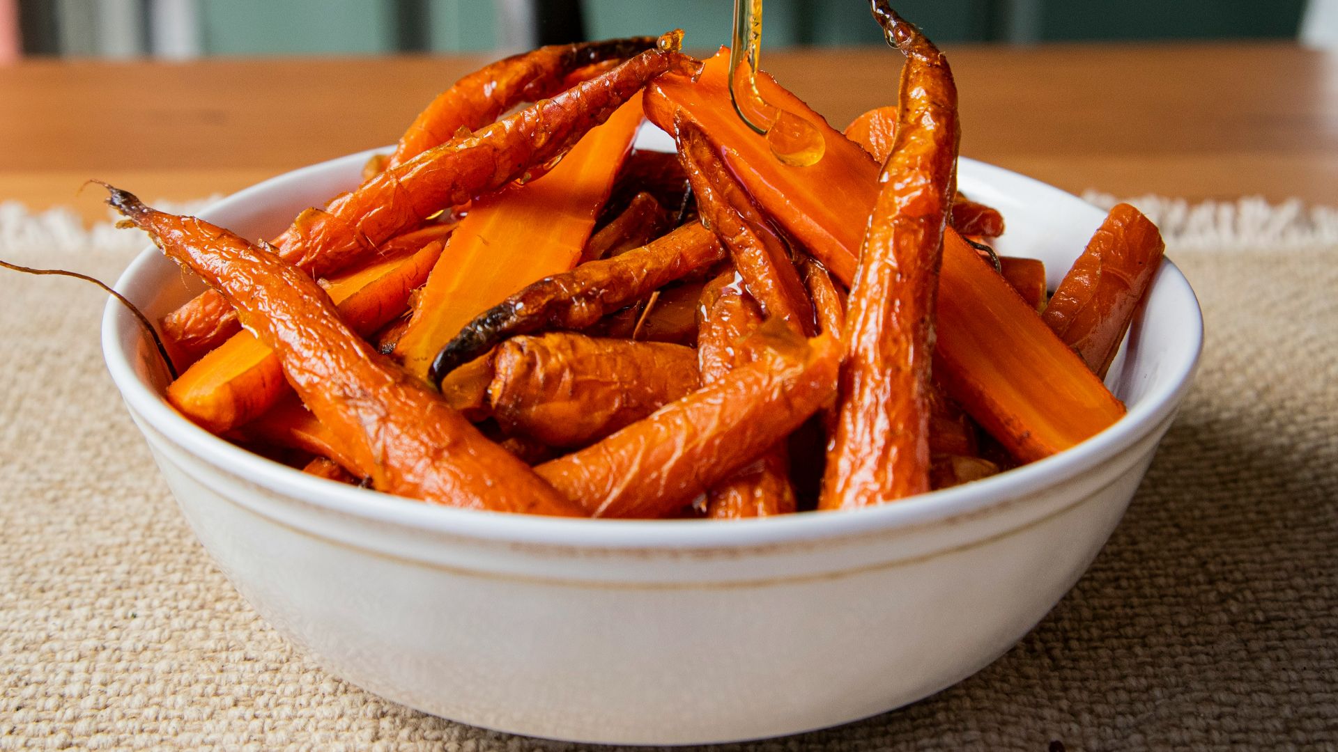 a white bowl filled with carrots sitting on top of a table