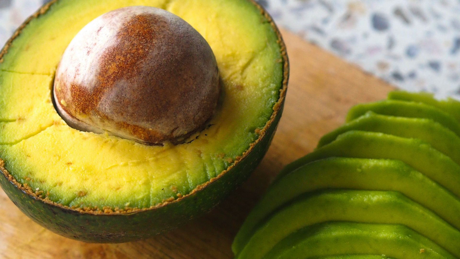 an avocado cut in half on a cutting board