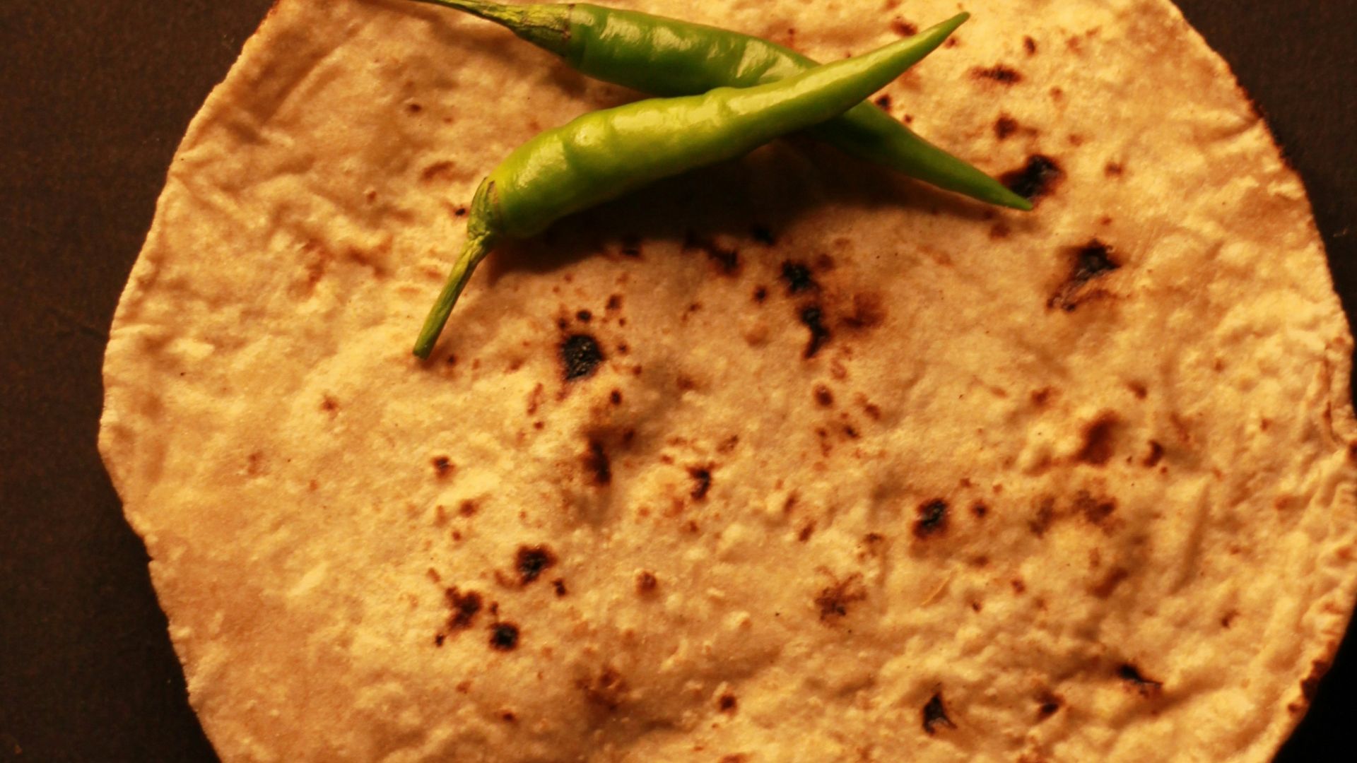A tortilla with a green pepper on top of it