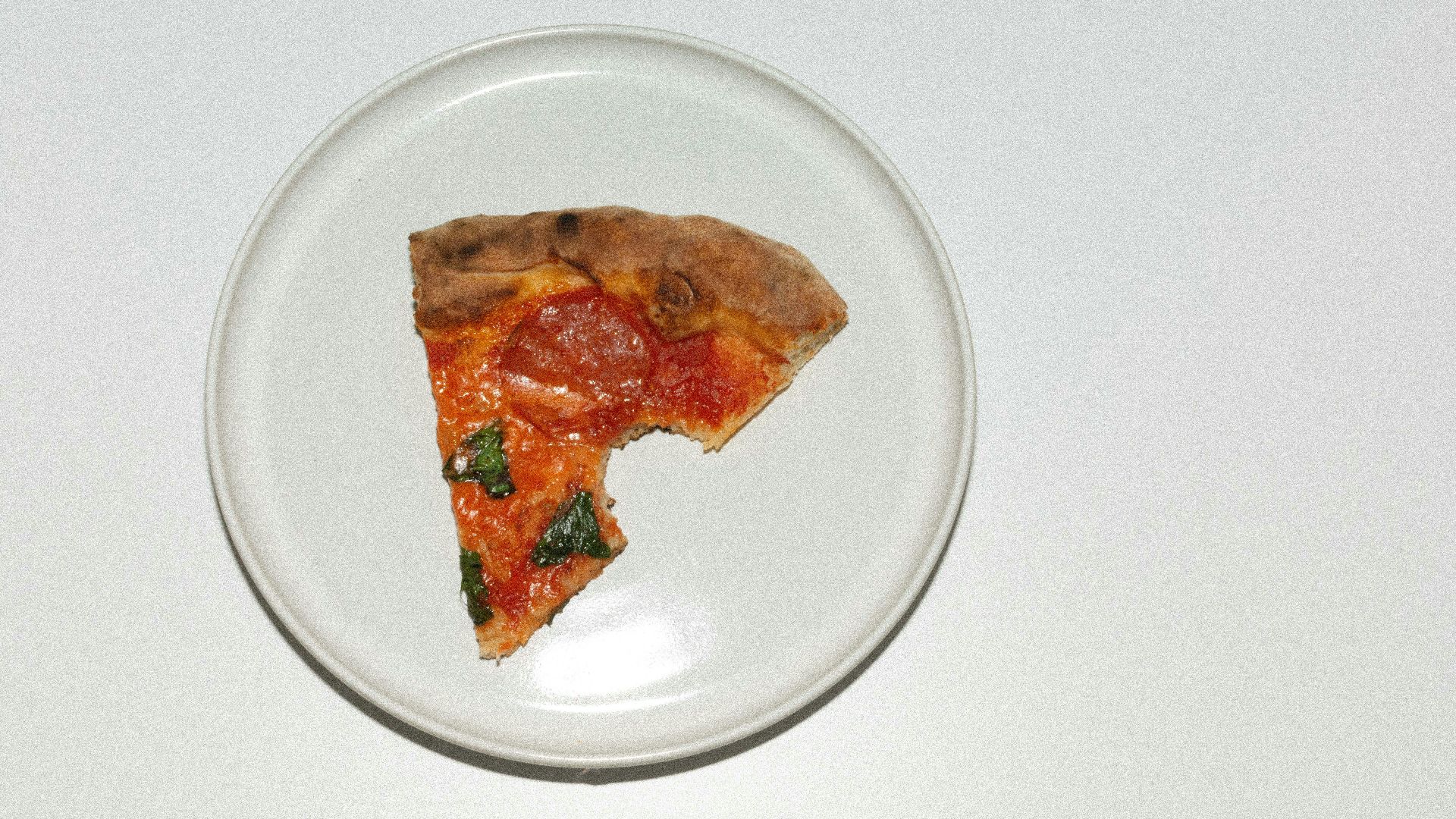 a slice of pizza on a plate on a table