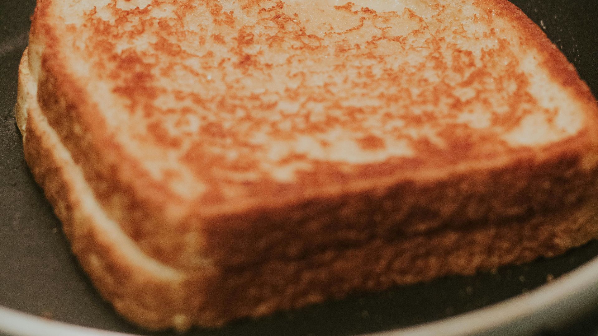 a toasted sandwich sitting on top of a black pan