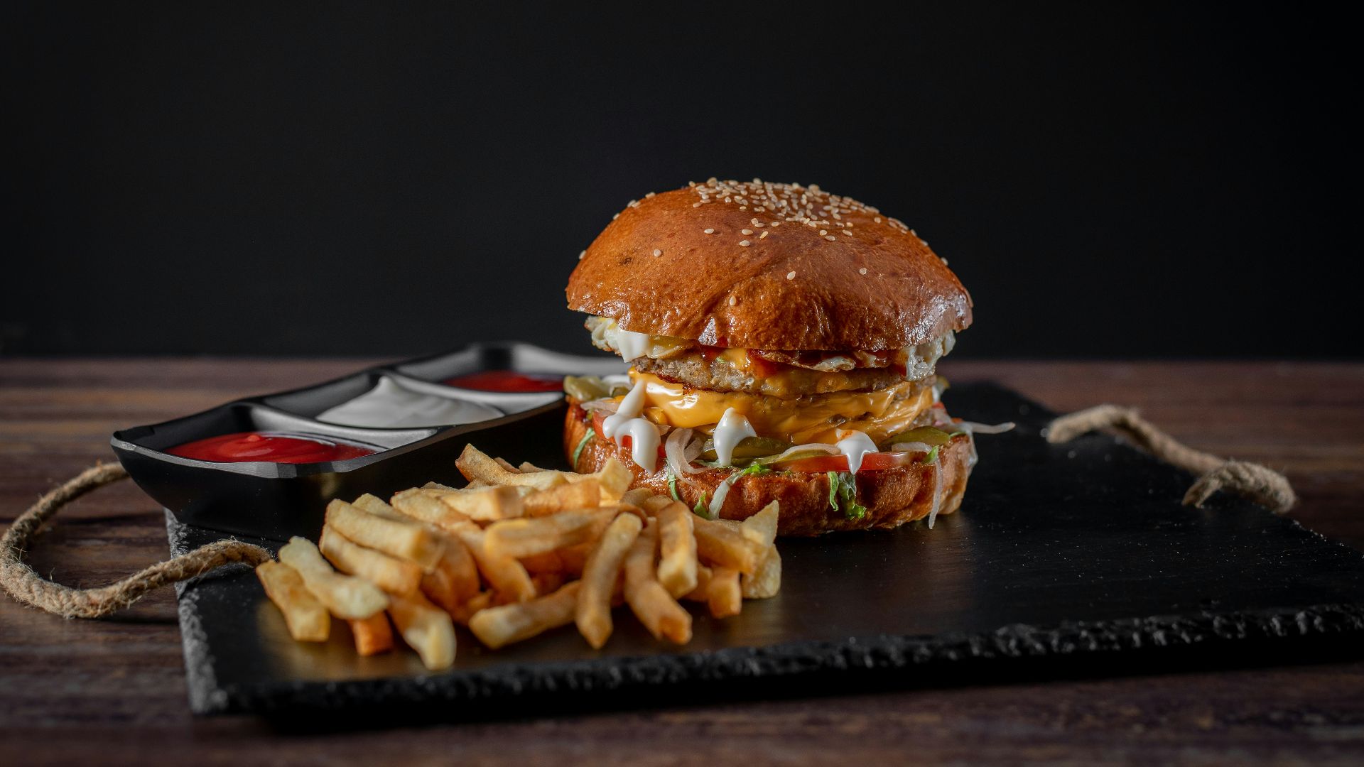 burger with fries on black plate