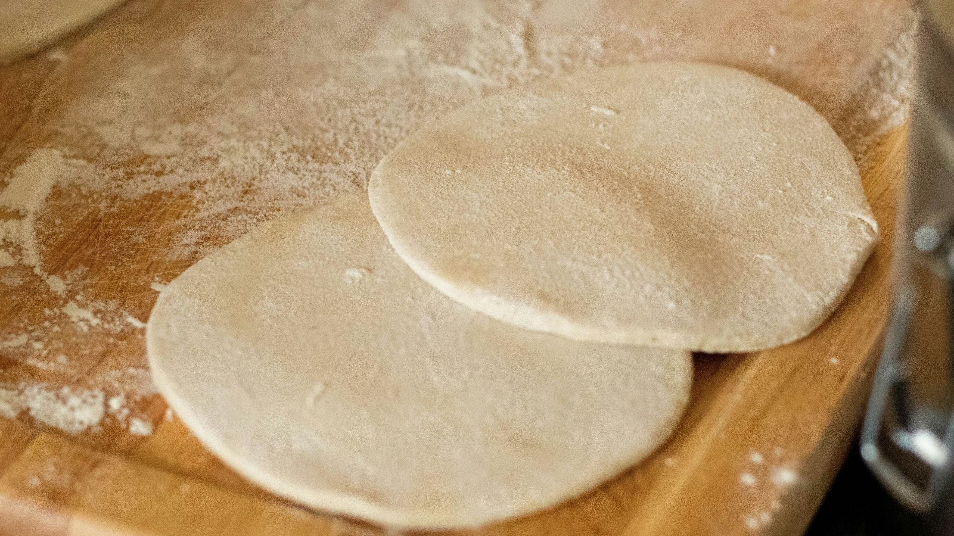 white dough on brown wooden chopping board