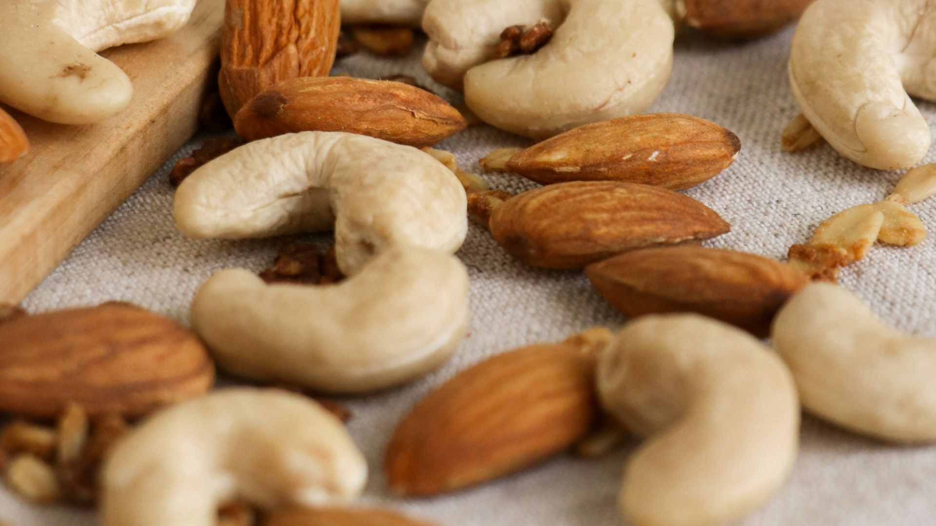 brown almond nuts on white textile