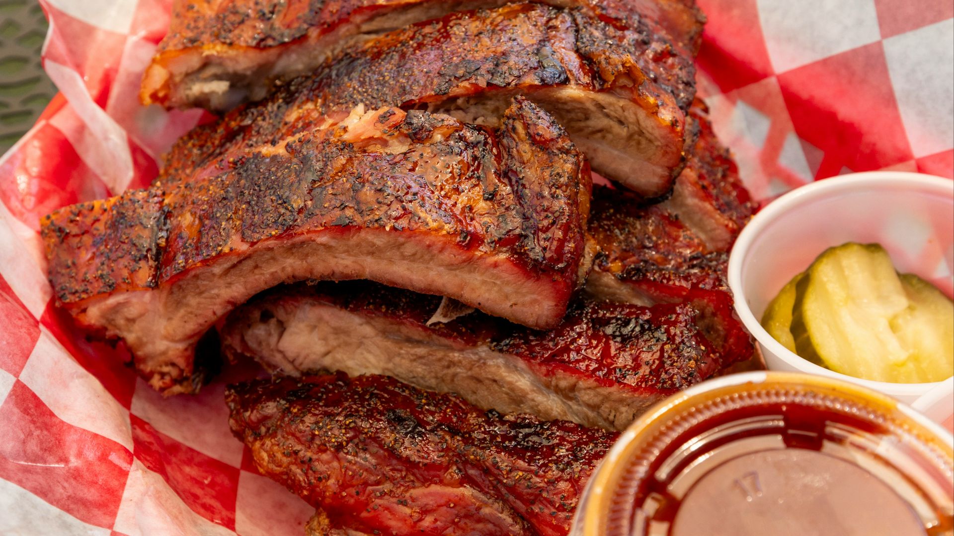 Stack of barbecued ribs with pickles and coleslaw