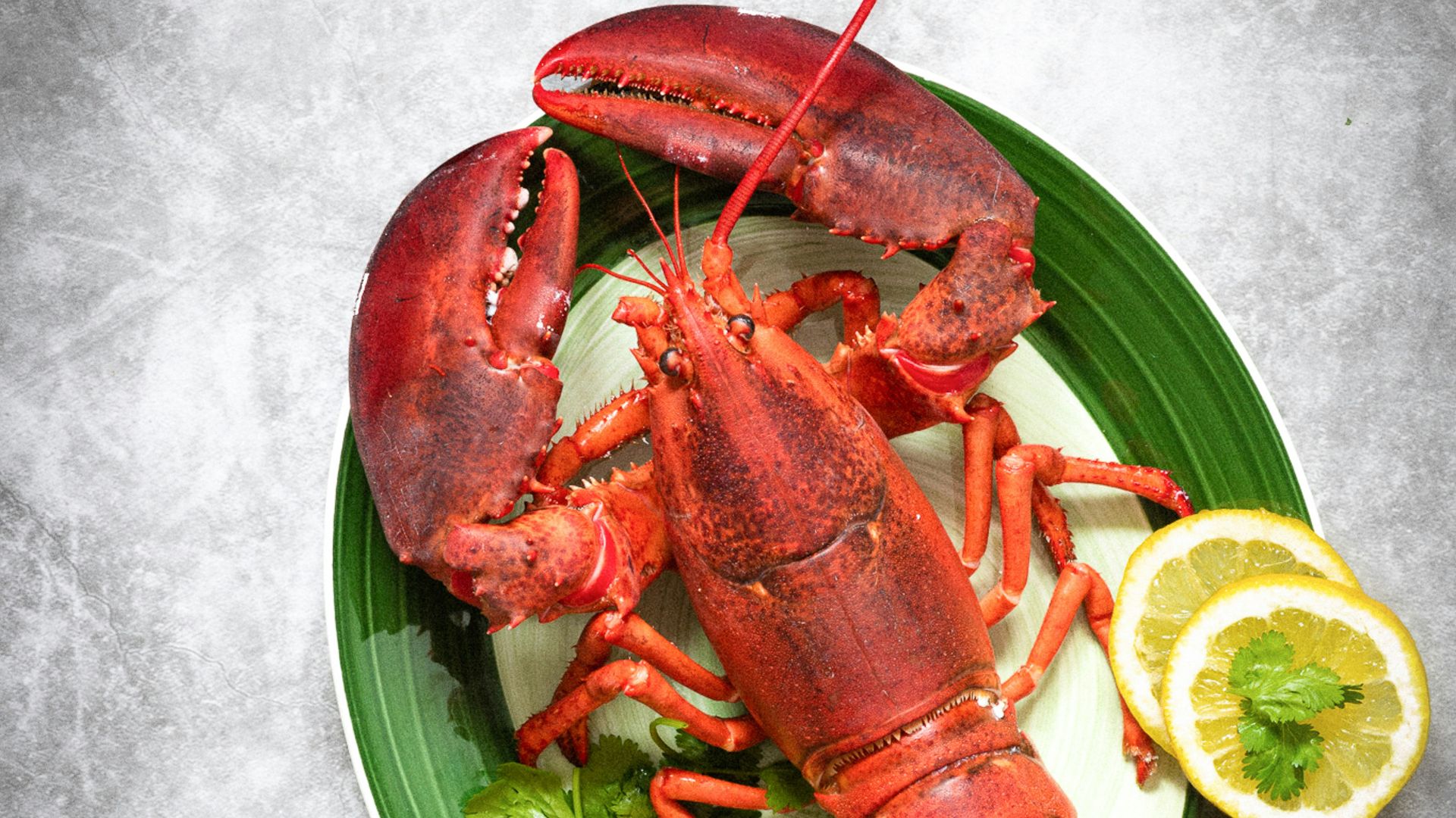 a plate of lobsters, lemons, and lettuce