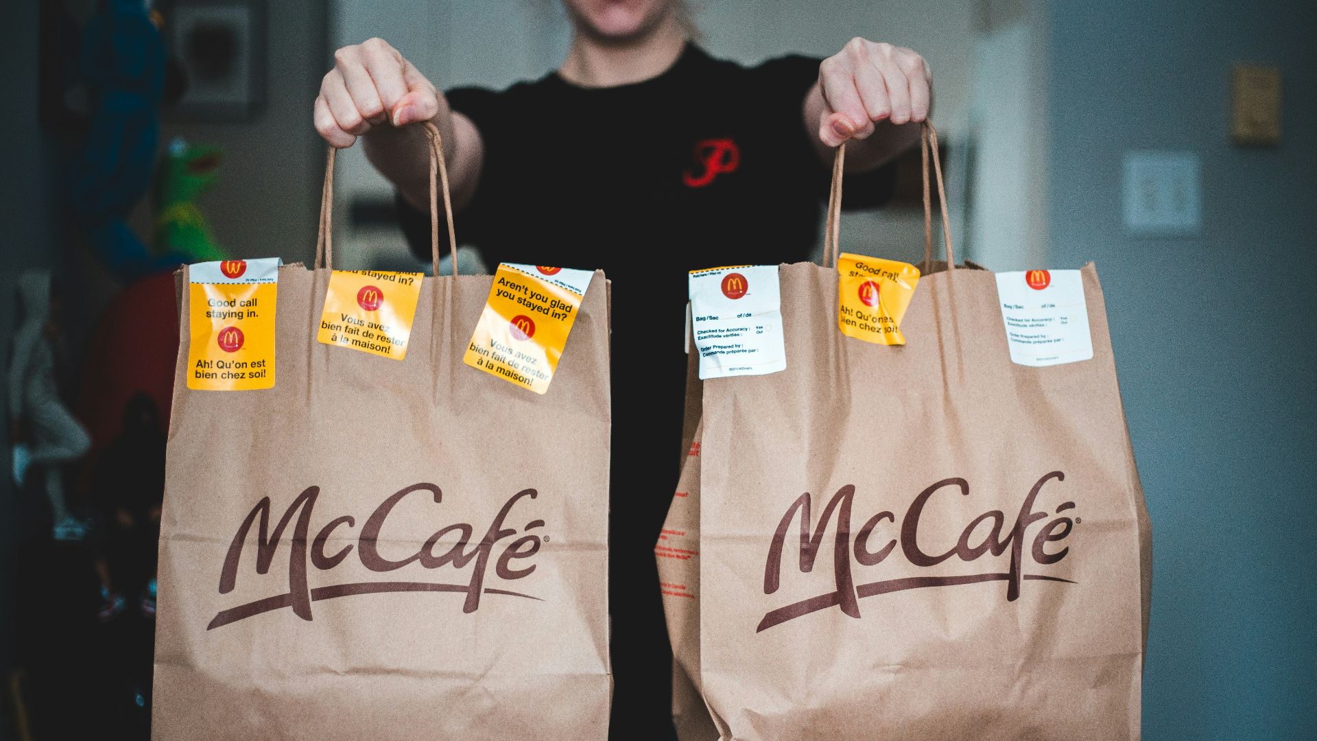 person holding white and brown tote bags