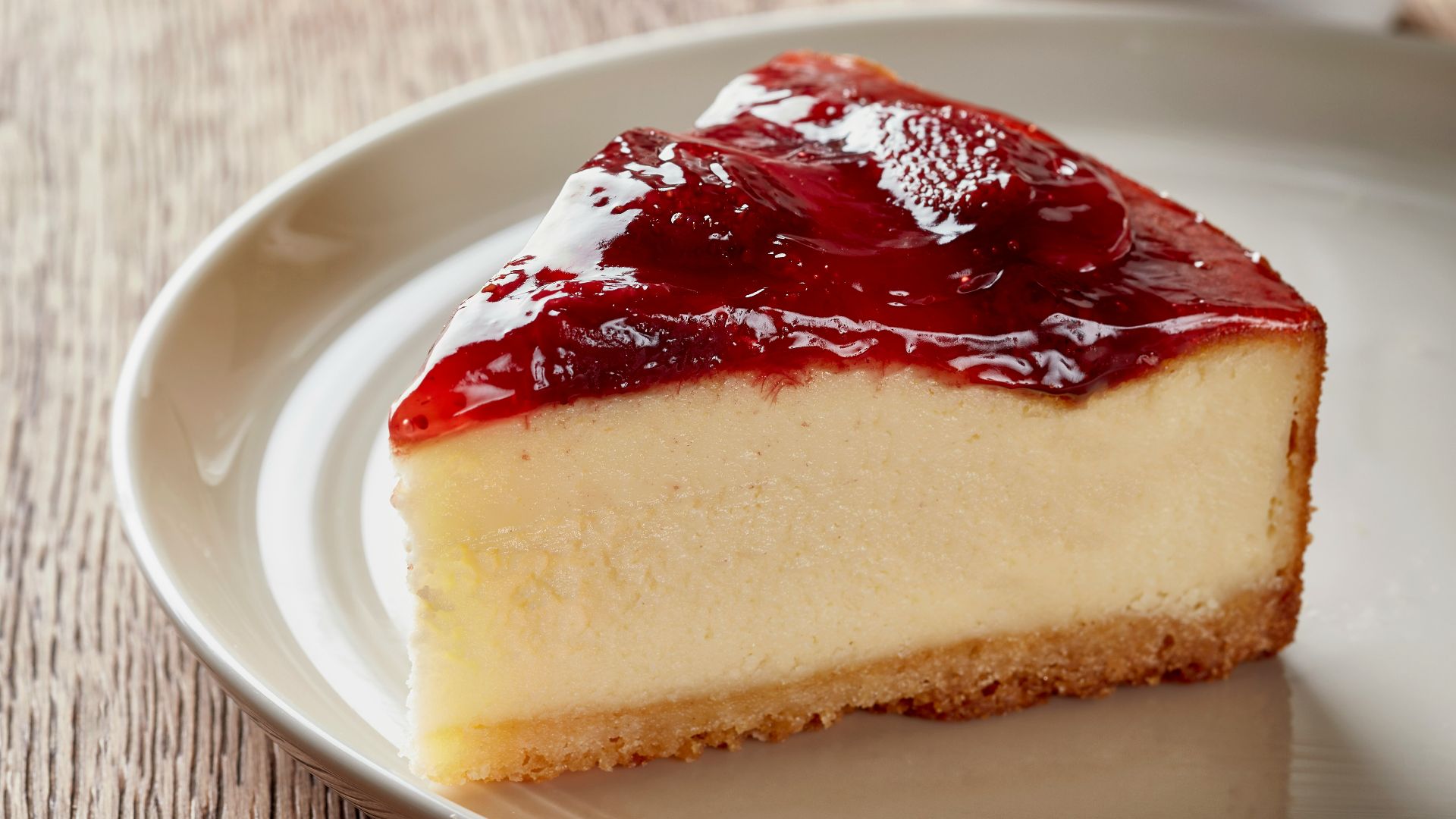 a piece of cheesecake on a plate next to a cup of coffee
