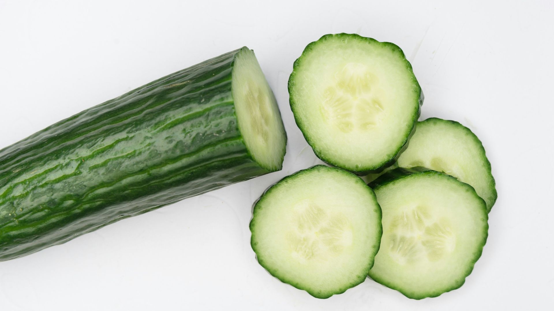 sliced cucumber on white surface