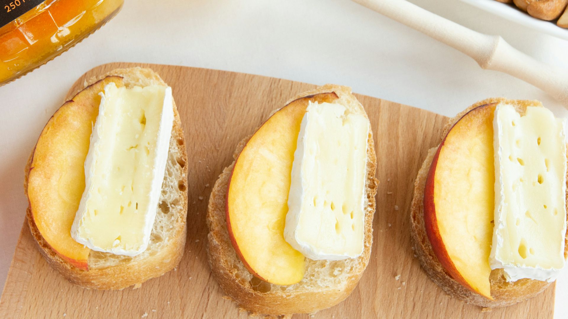 a wooden cutting board topped with three sandwiches