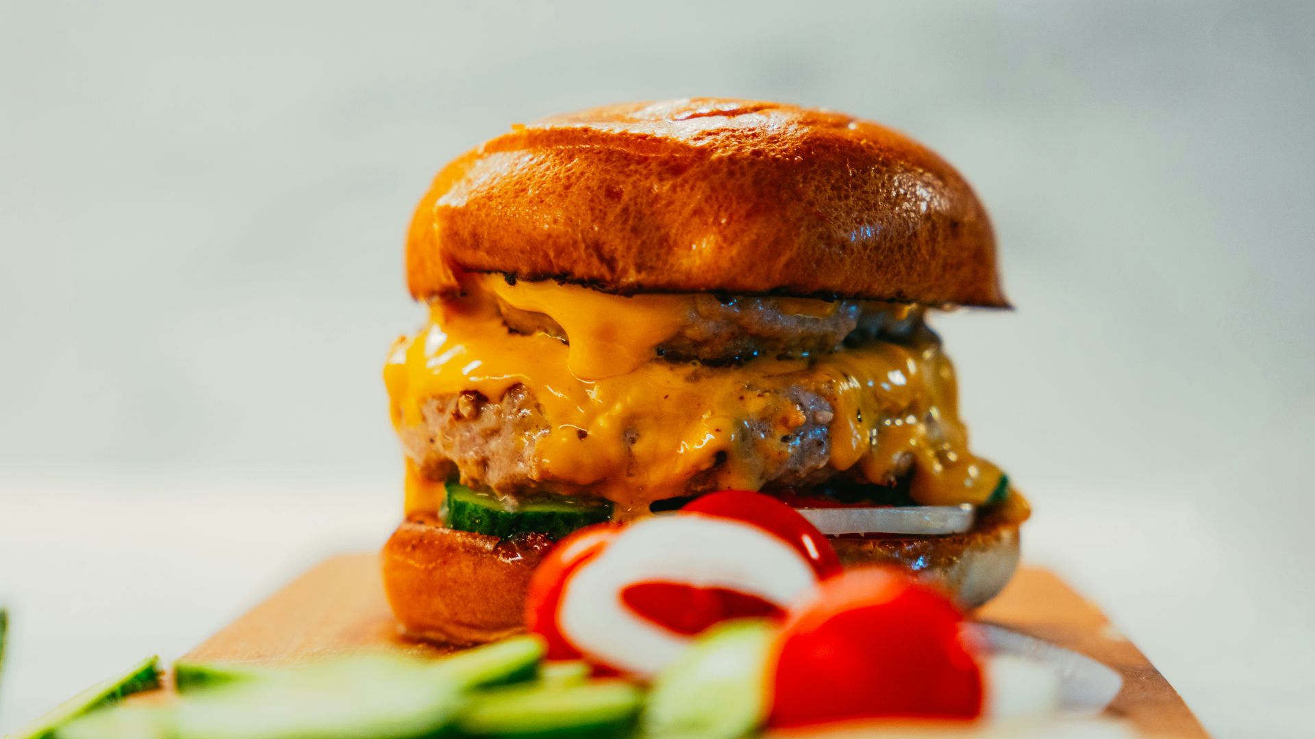 a cheeseburger sitting on top of a cutting board