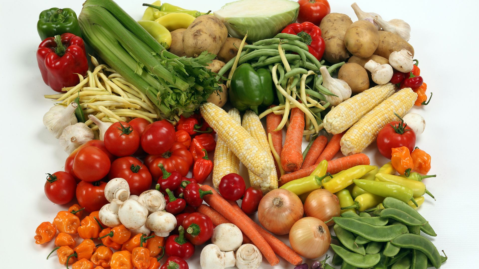 a pile of different types of vegetables on a white surface