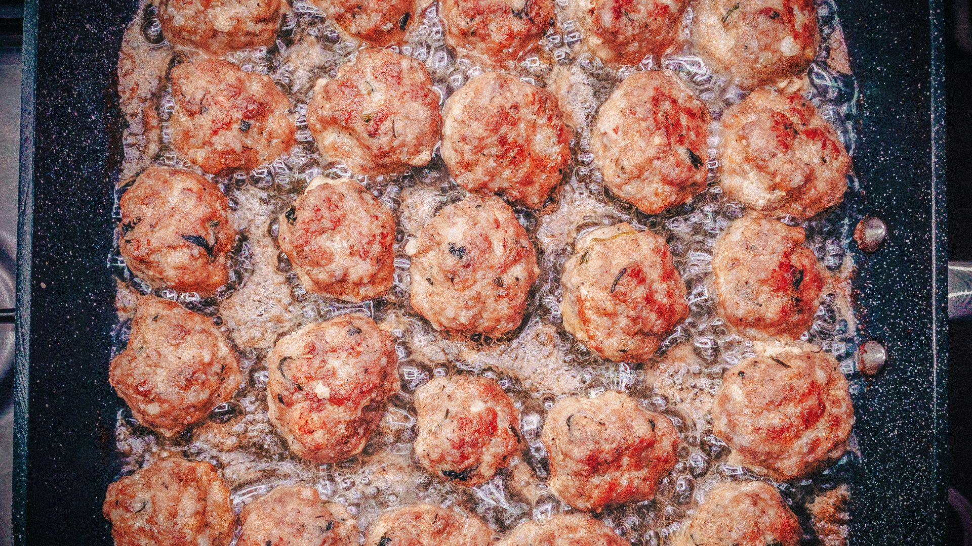 a pan filled with meatballs covered in sauce