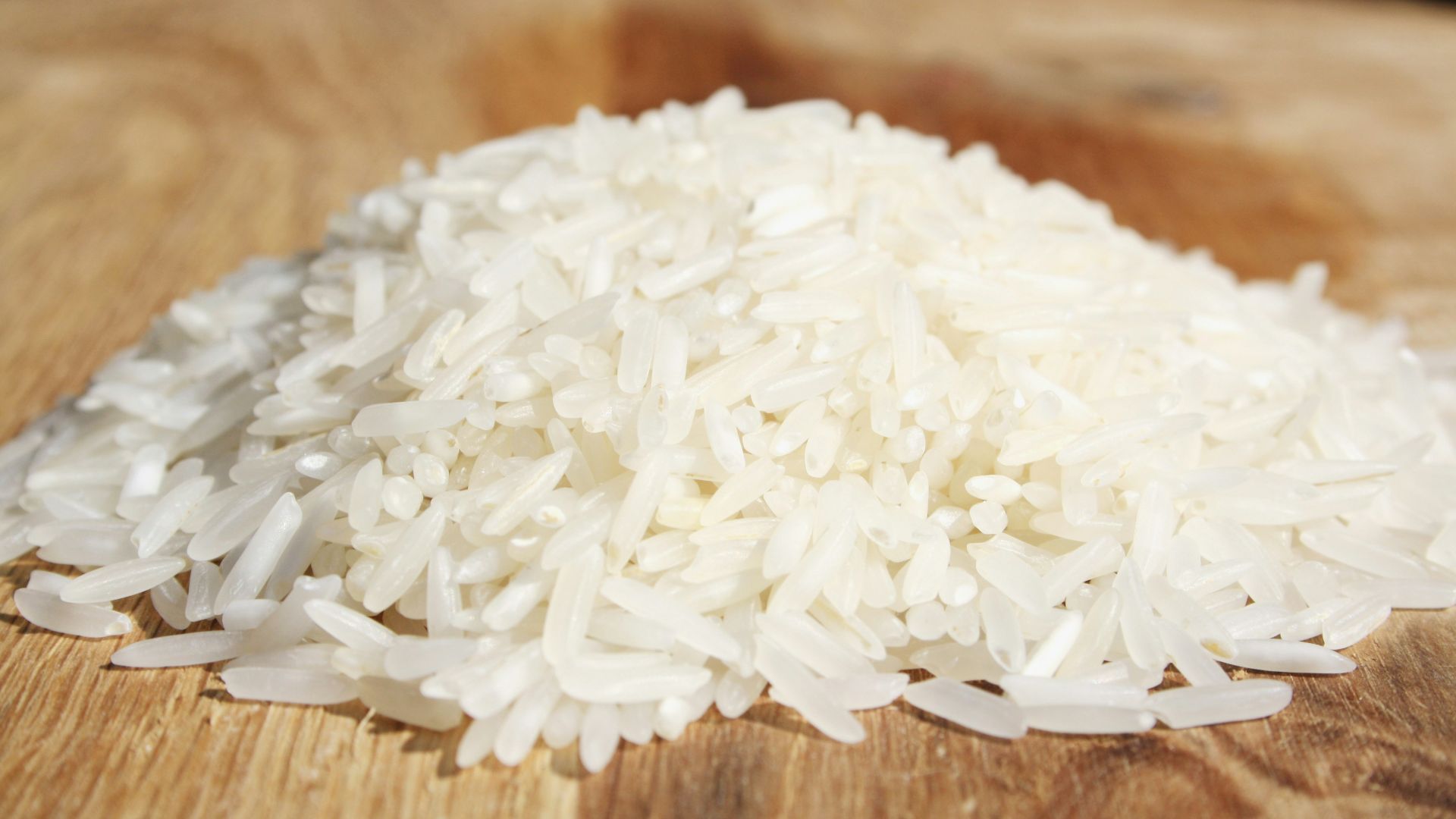 A pile of rice sitting on top of a wooden cutting board