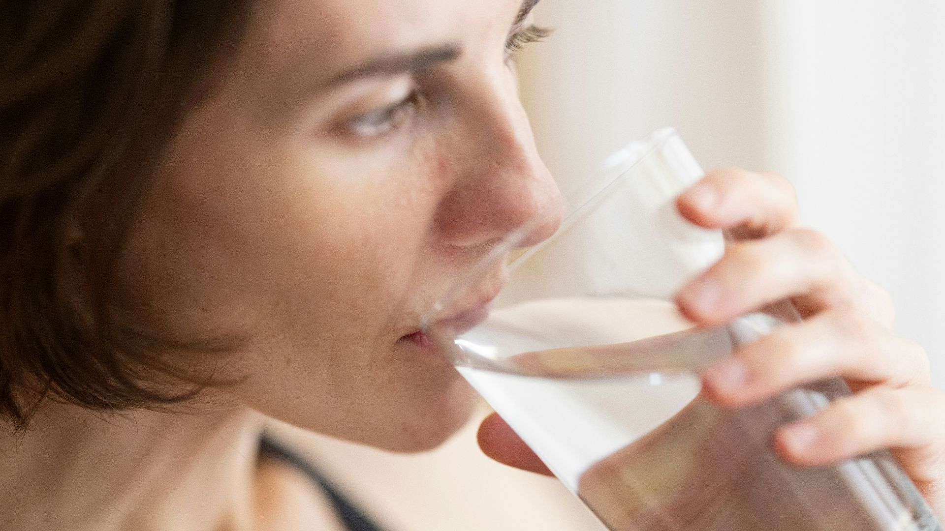 woman in black tank top drinking water