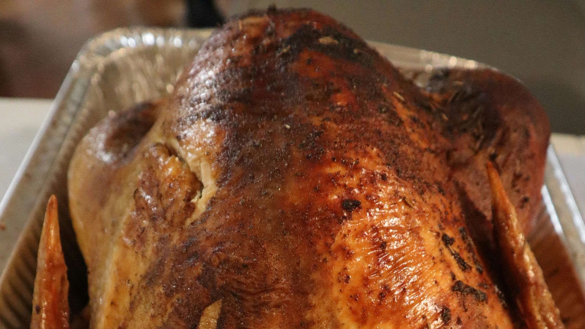 A roasted turkey sitting on top of a pan