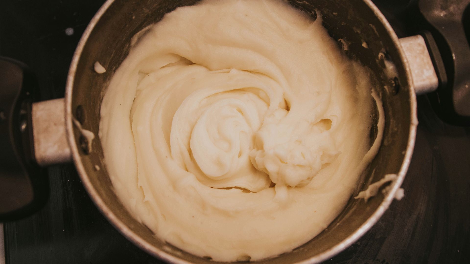a pot of cream sitting on top of a stove