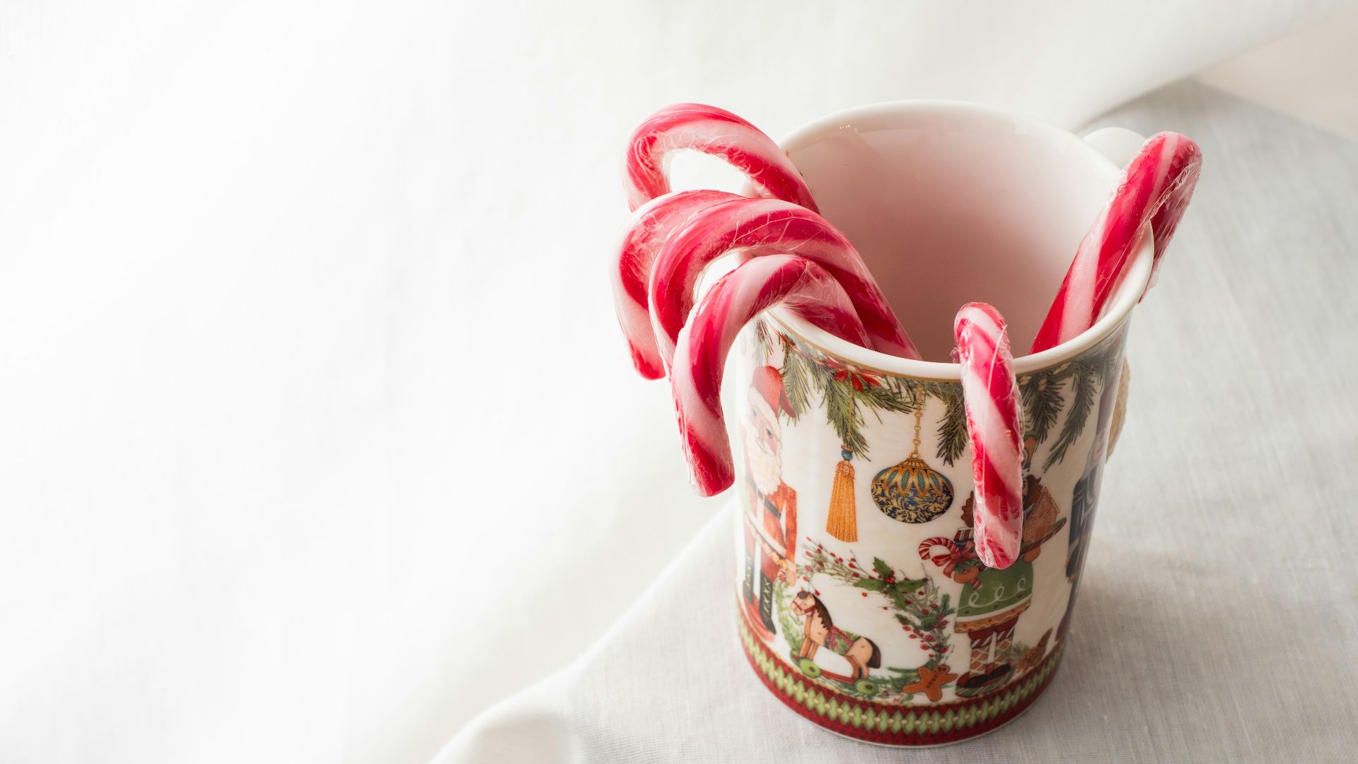 a cup with candy canes in it sitting on a table