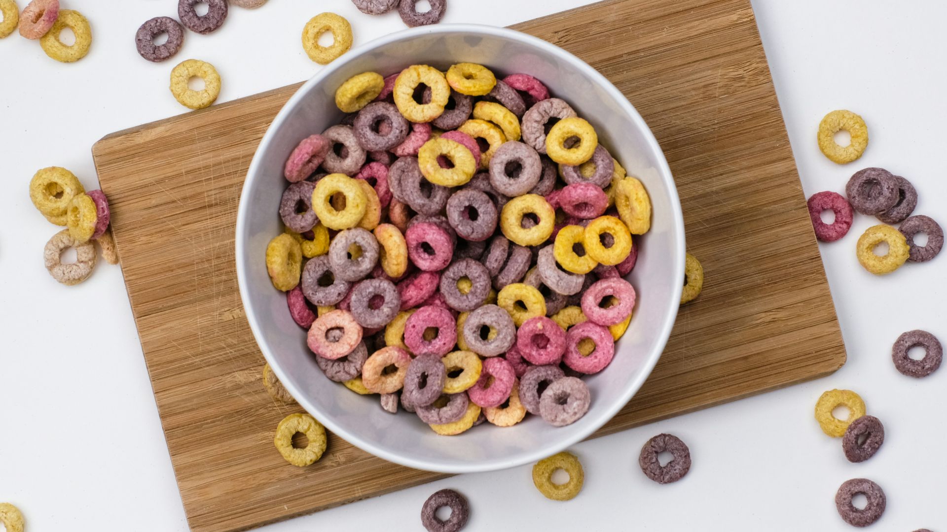 red and blue berries on white ceramic bowl on brown wooden chopping board