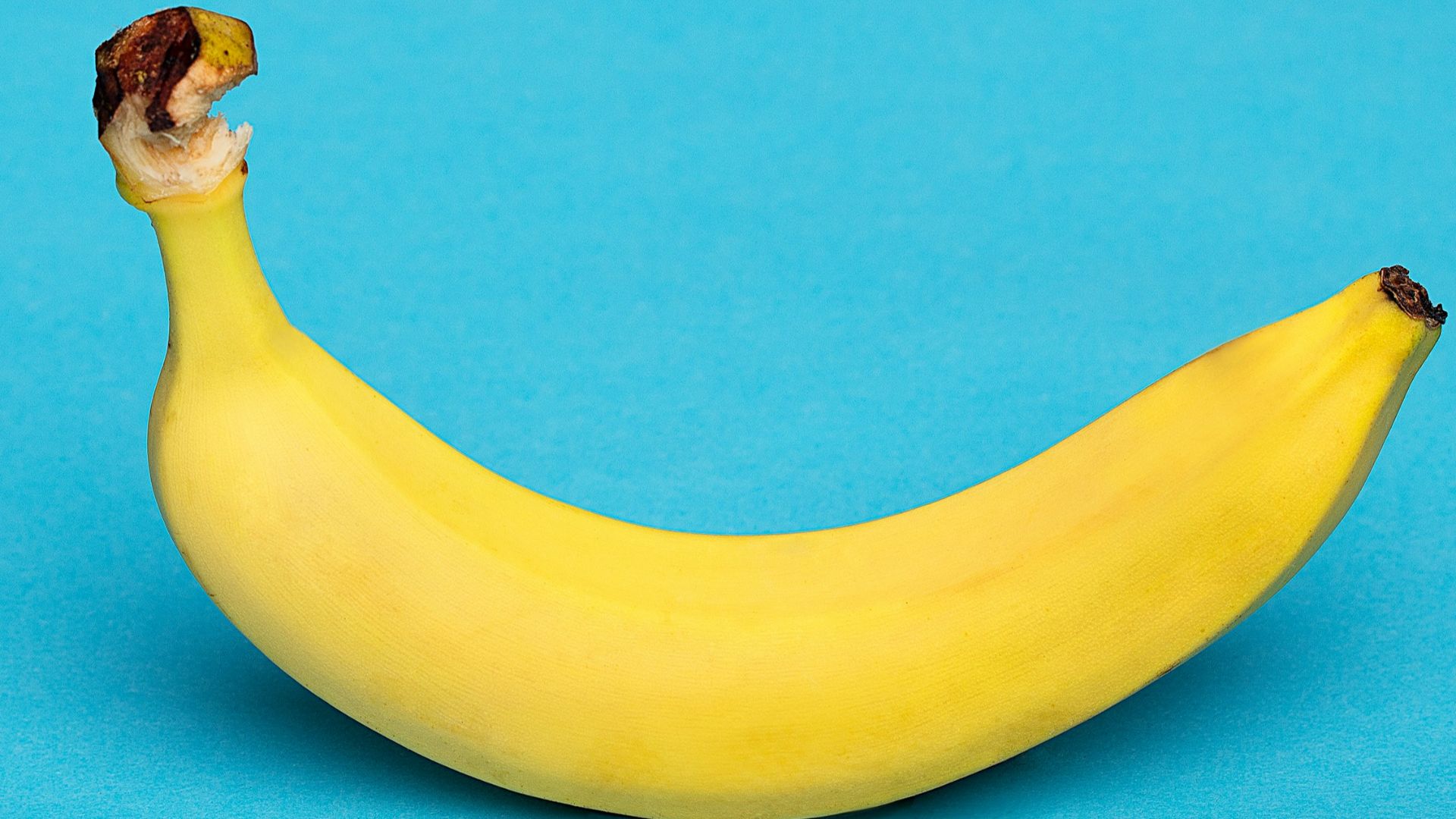 yellow banana fruit on blue surface