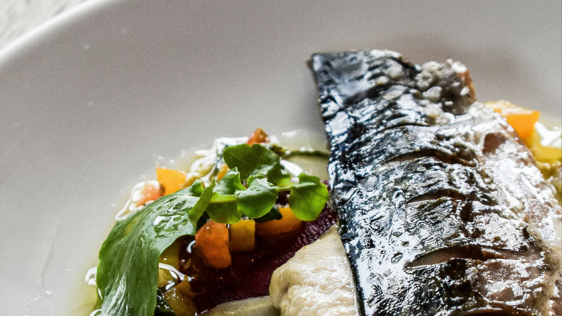 a white plate topped with fish and vegetables