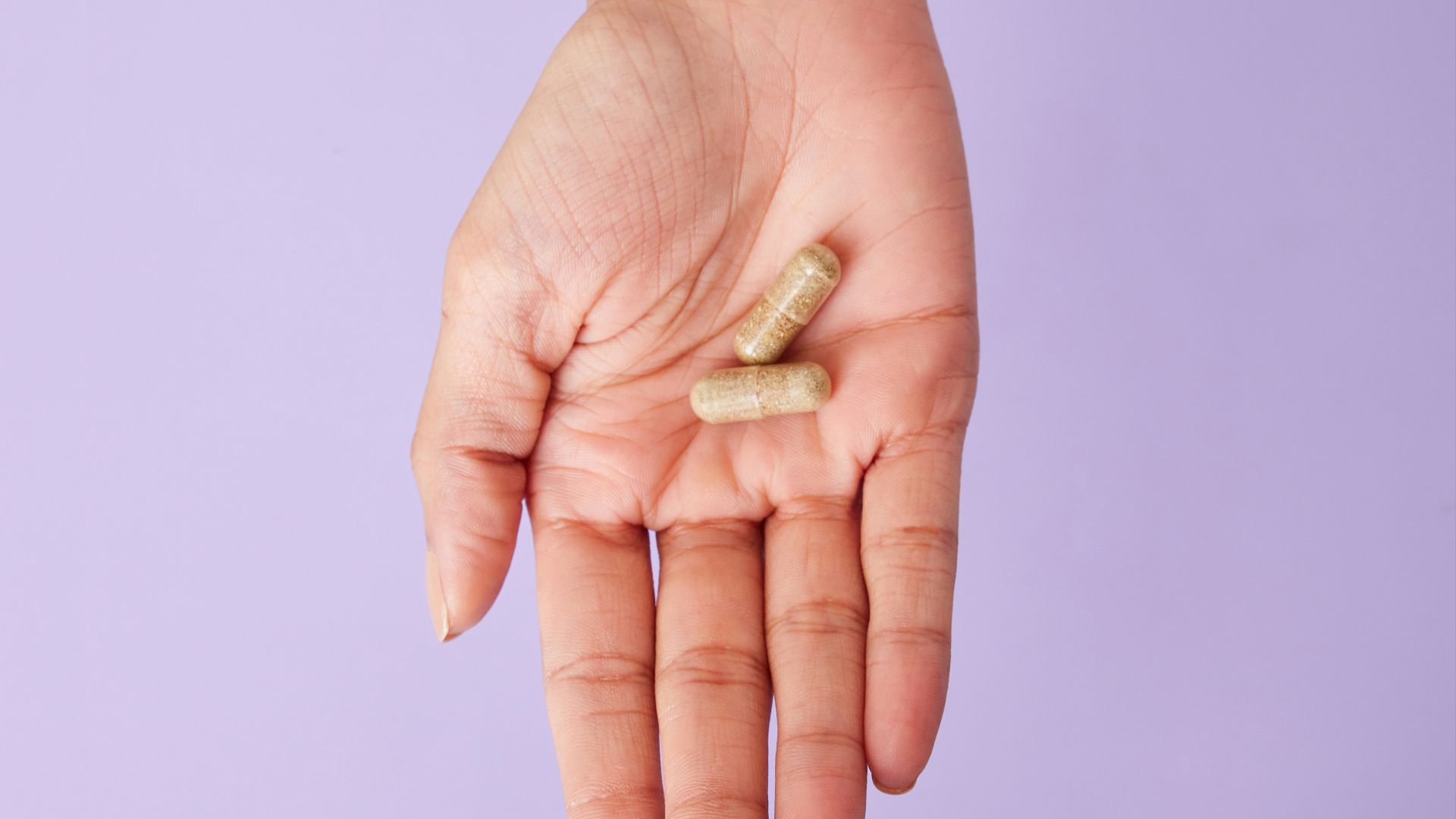 A person holding a pill in their hand