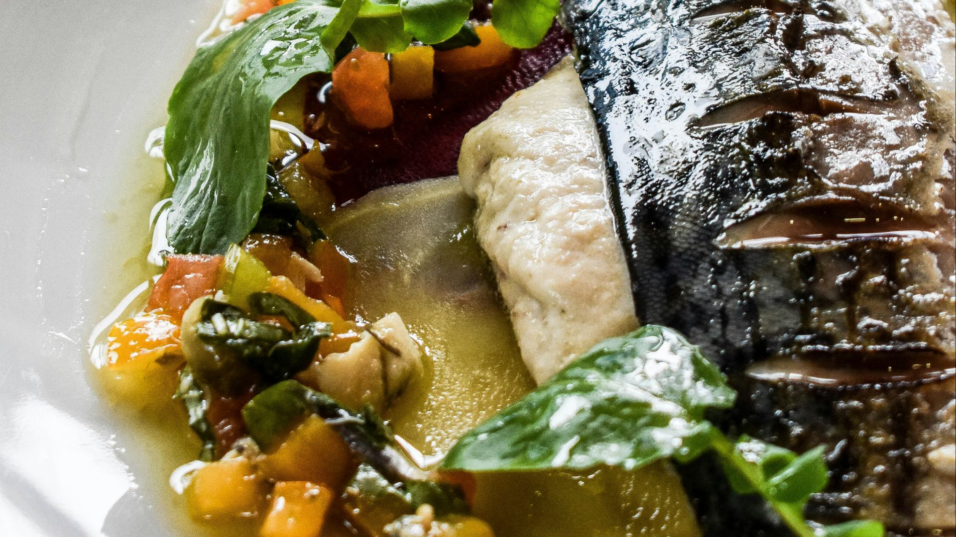 a white plate topped with fish and vegetables