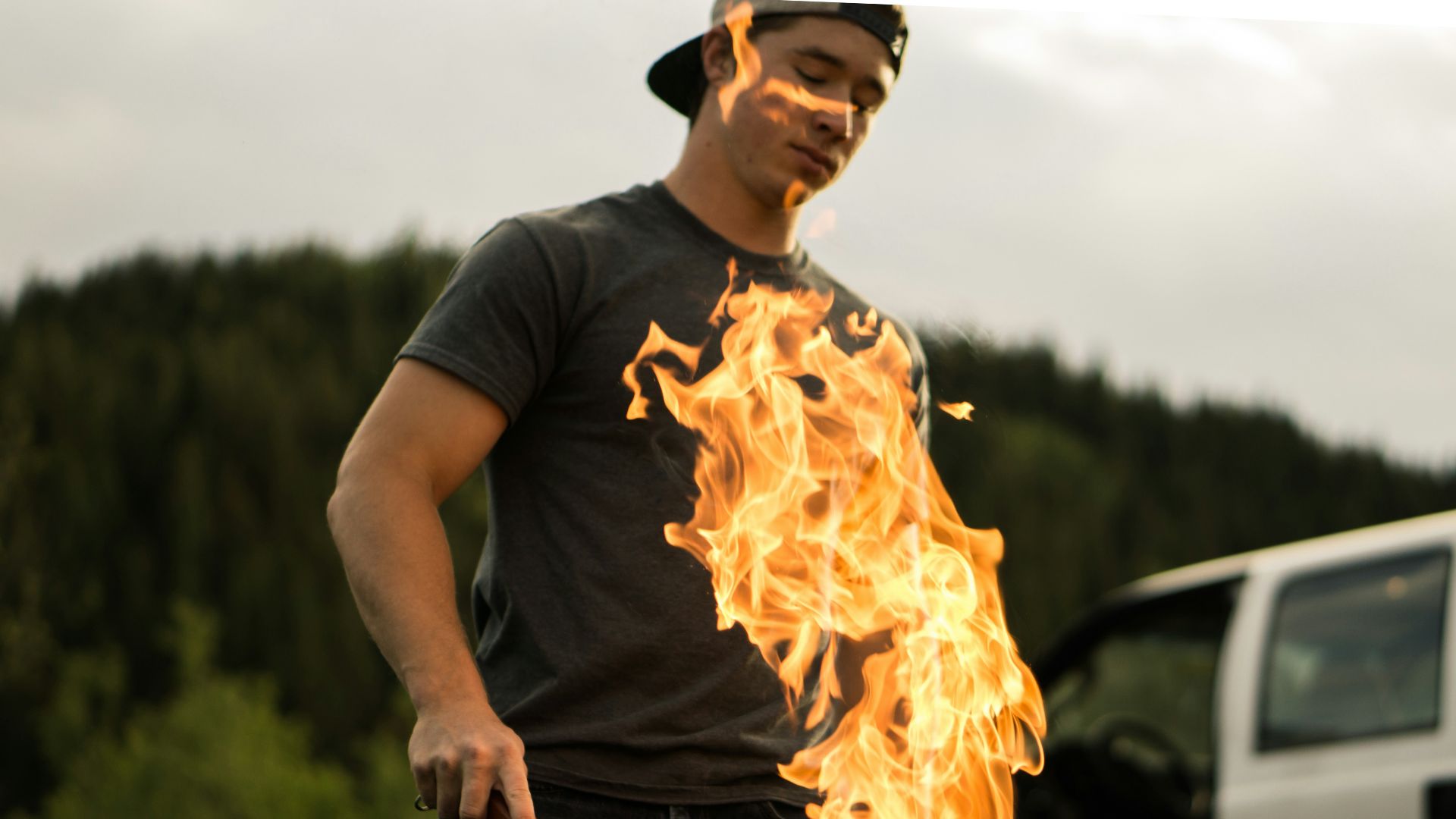 man grilling near white vehicle