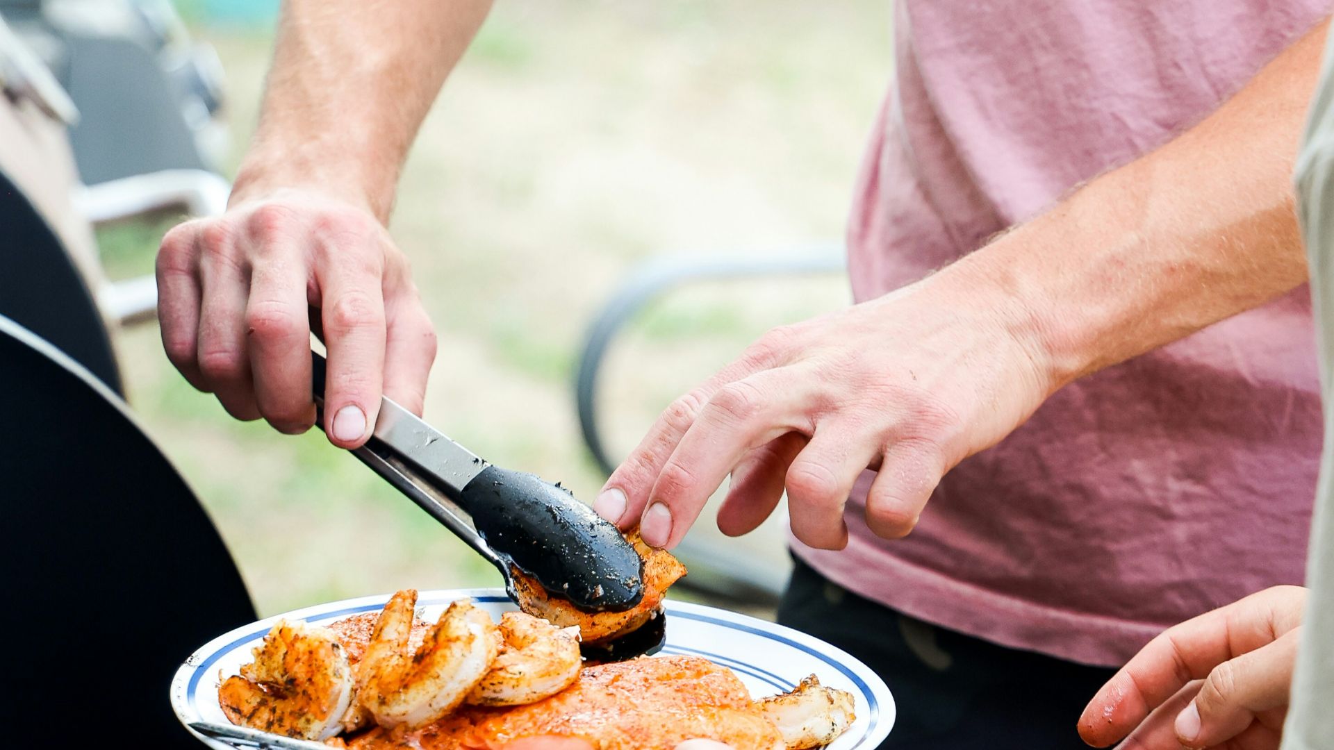 a couple of men standing over a plate of food