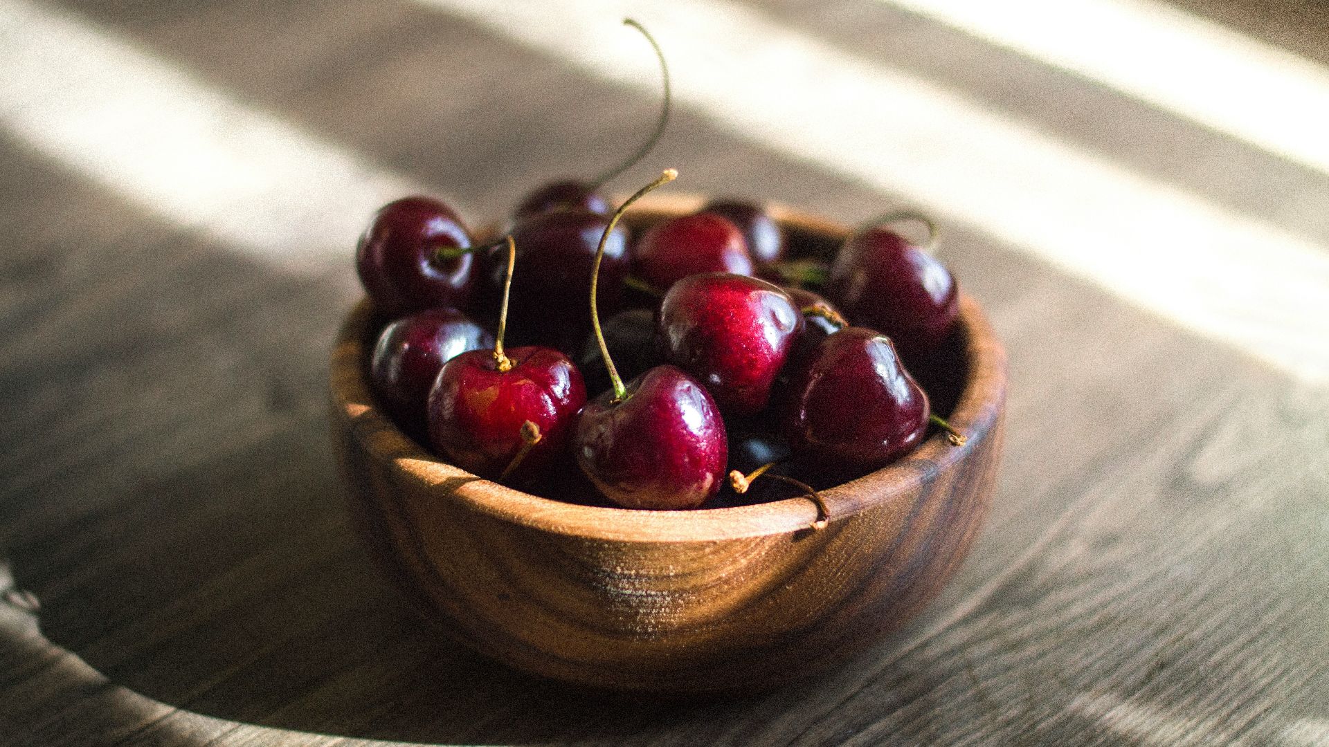 bunch of red cherries in brown bowl