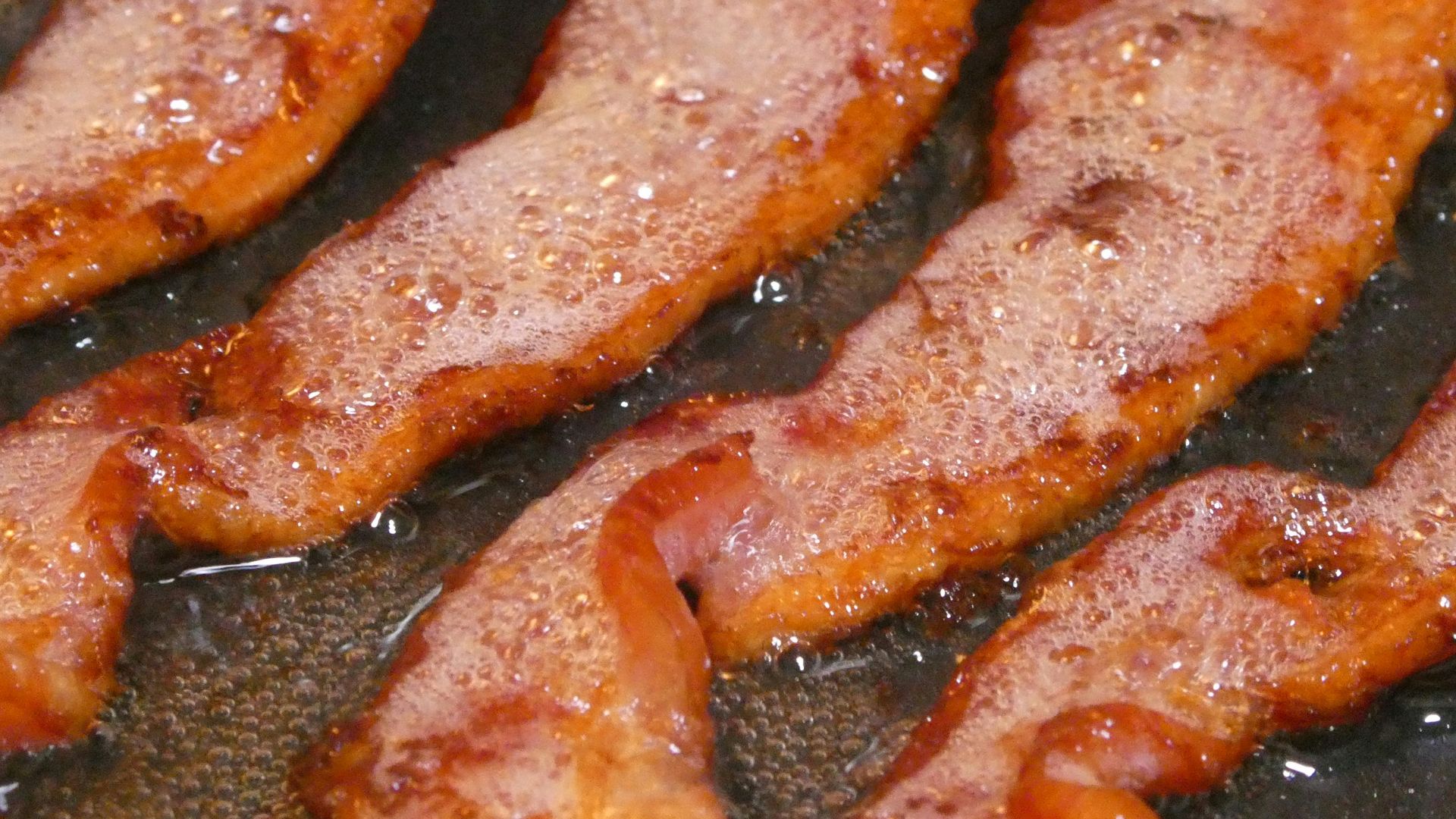 a close up of a frying pan filled with bacon